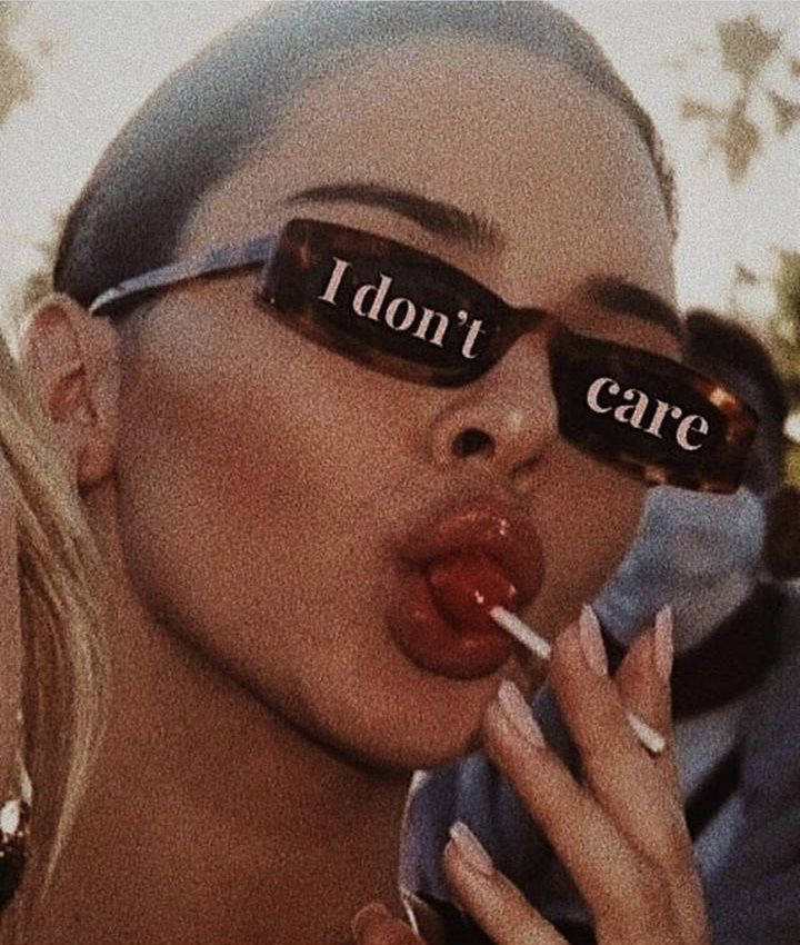 戴著帶文字太陽眼鏡的女性舔著紅色棒棒糖