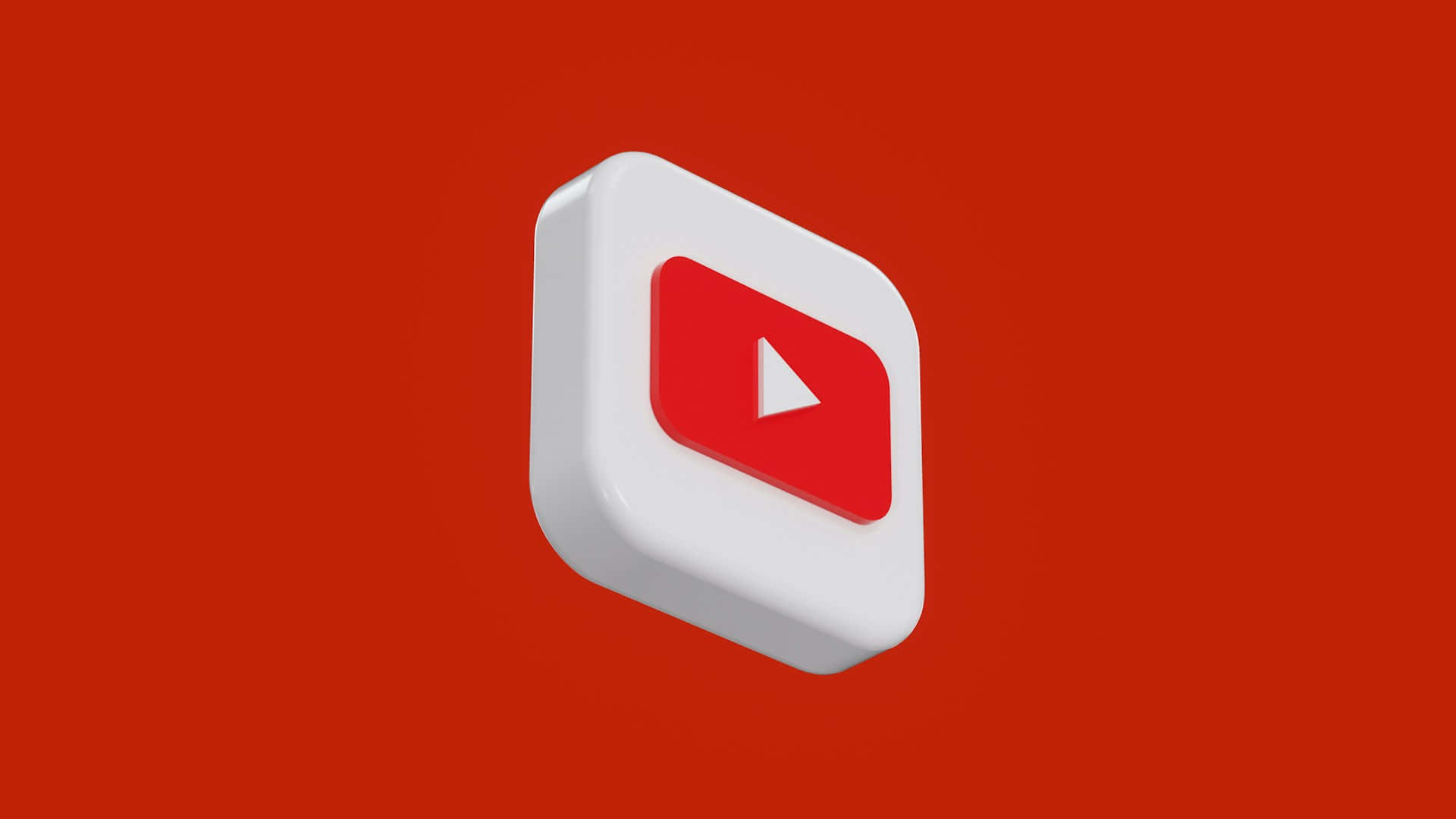  壁紙 — 一個3D渲染的YouTube播放按鈕圖標漂浮在純紅色背景上，帶有柔和陰影。