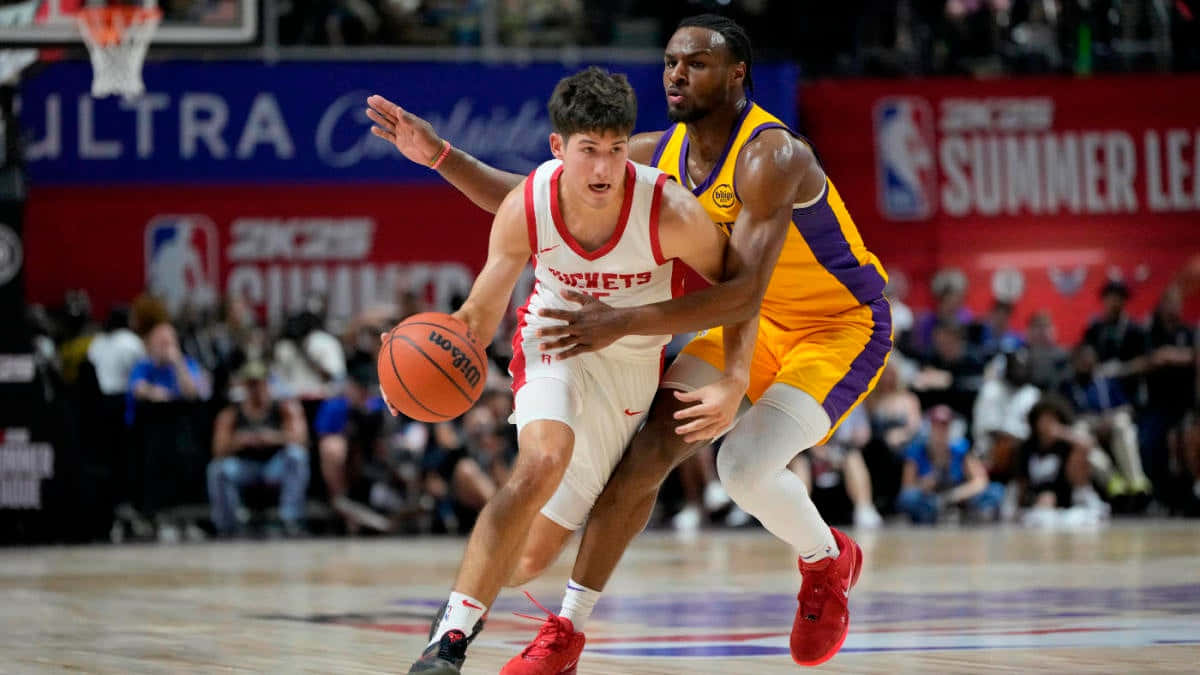  壁紙 — 一名身穿白色火箭隊球衣的籃球運動員在NBA夏季聯賽比賽中運球，同時被一名身穿黃色湖人隊球衣的球員緊密防守。