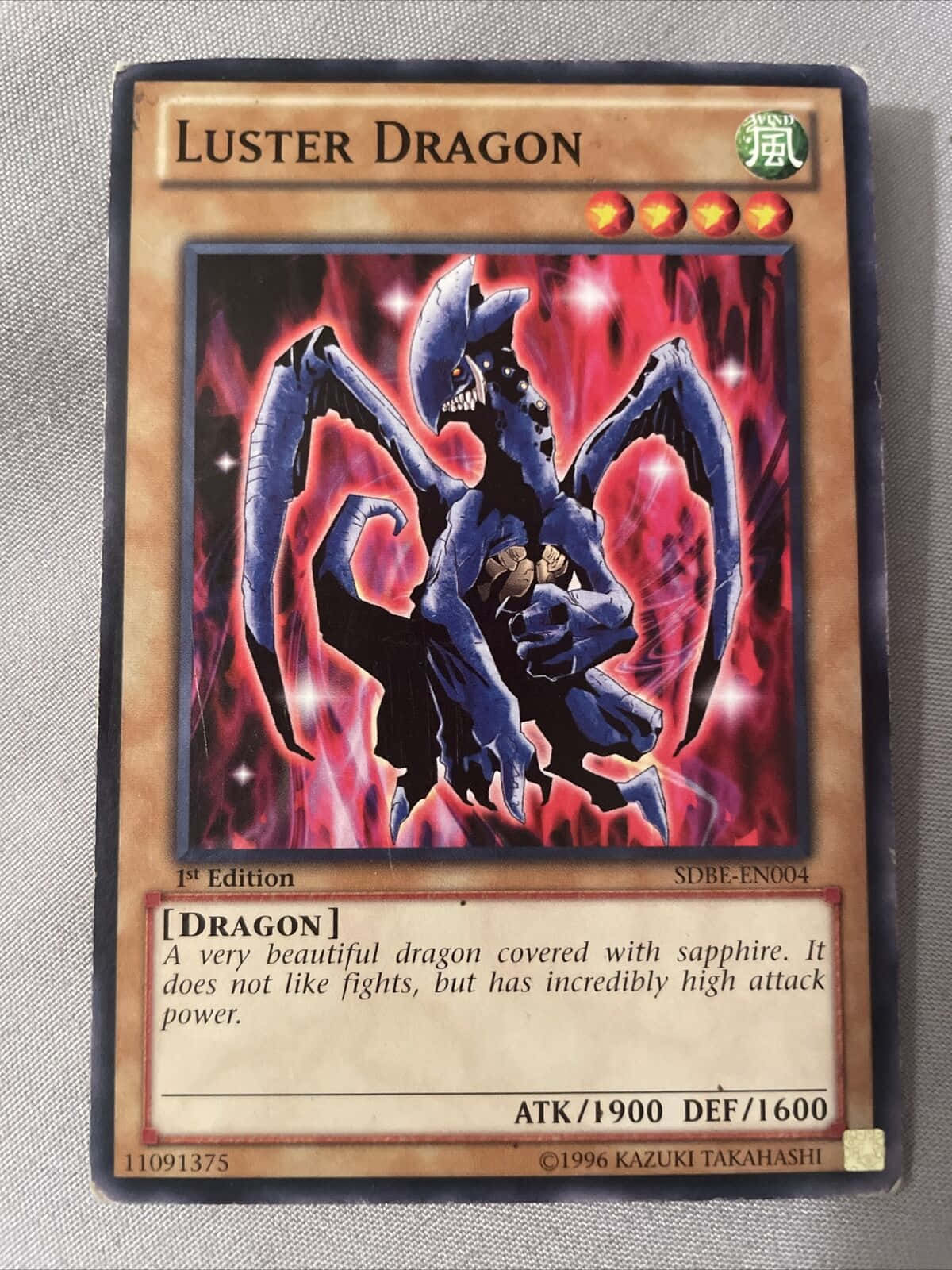 Yugioh Dragons 桌布 壁紙 — 一隻擁有藍寶石般鱗片和蝙蝠般翅膀的藍色龍，從遊戲王集換式卡牌上的火紅烈焰中現身。