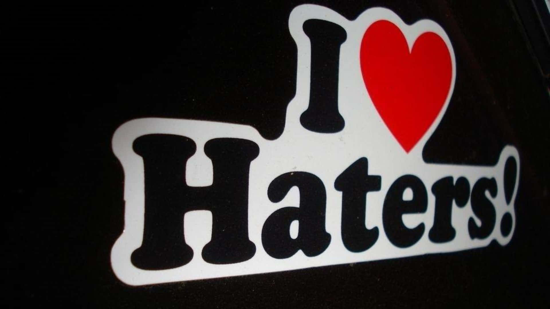  壁紙 — 一個大膽的黑白貼紙，上面有一個紅色心形，寫著「I Love Haters!」，貼在深色表面上。