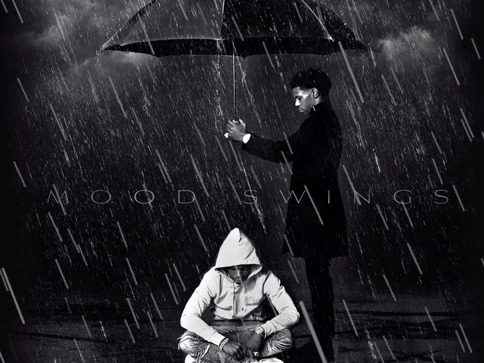 雨中兩個人，一個企喺度揸遮，一個蹲低