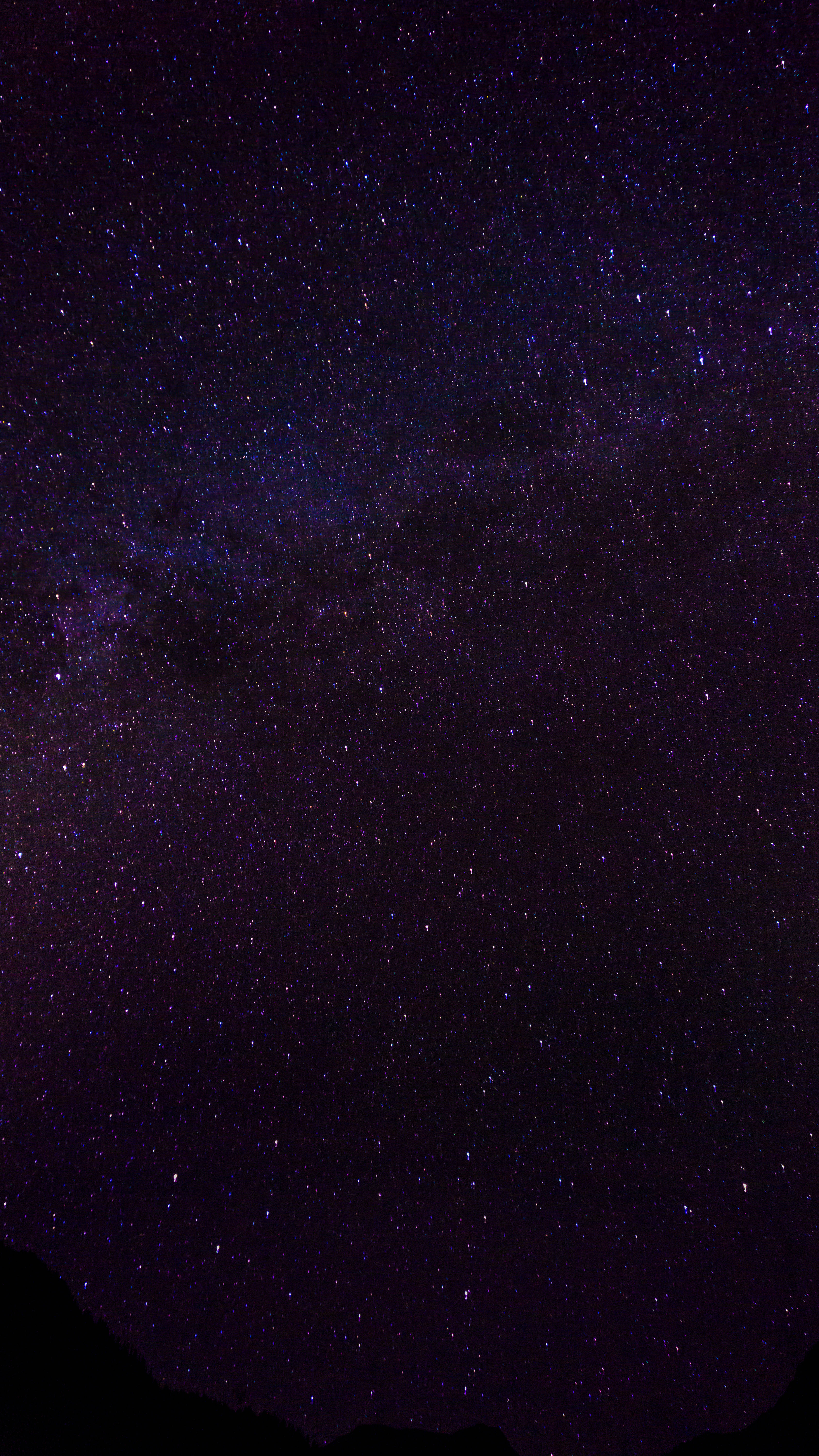 深紫色星系在太空中的美麗景象 壁紙 — 令人嘆為觀止的銀河系景觀，紫色和藍色星星在深邃的夜空中閃耀，映襯著黑暗的山巒輪廓。