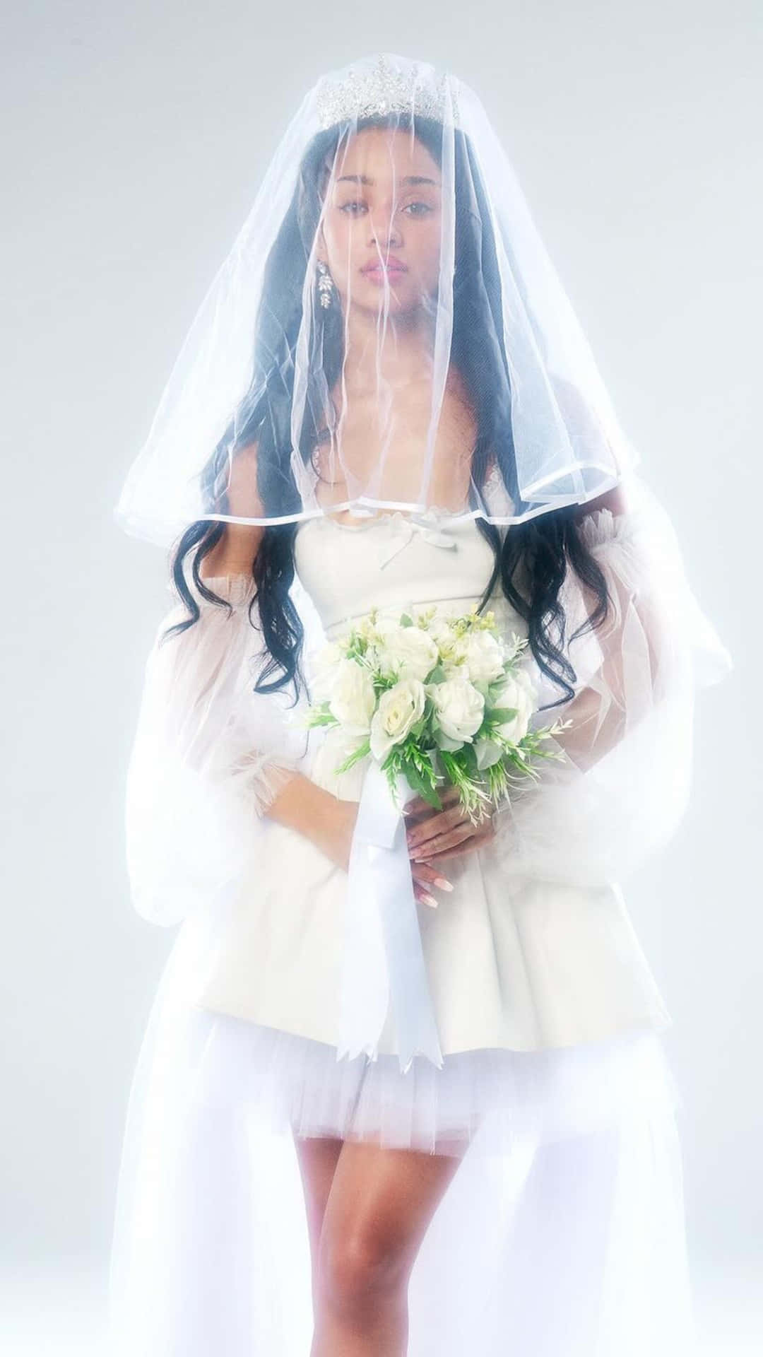  壁紙 — 一位身穿白色頭紗和婚紗的新娘，在純白色背景前手持一束白玫瑰。