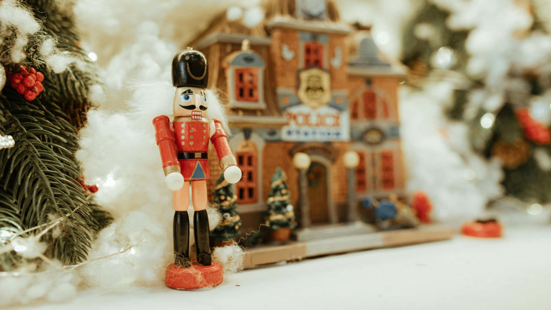  壁紙 — 一個經典的胡桃夾子士兵在一個裝飾著聖誕節的微型雪地警察局前站崗。