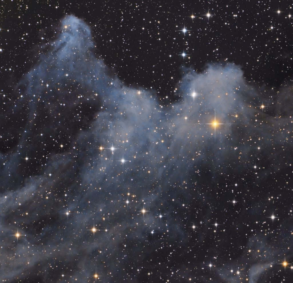 Interstellar Cloud 桌布 壁紙 — 一個宇宙星雲，帶有發光的藍色雲團和閃爍的星星，背景是深邃的黑色虛空。