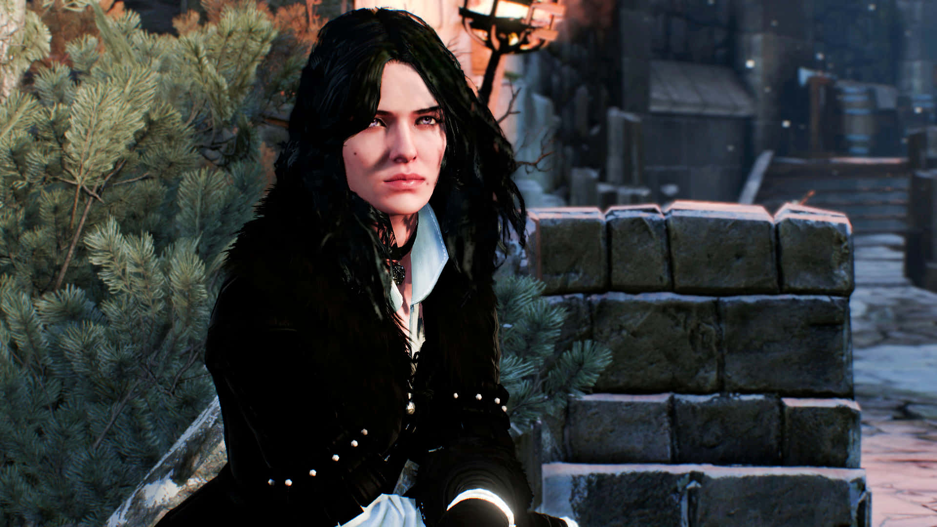 Yennefer 桌布 壁紙 — 一位黑髮女子身穿黑色外套，坐在中世紀昏暗小巷中常青樹旁的石階上。