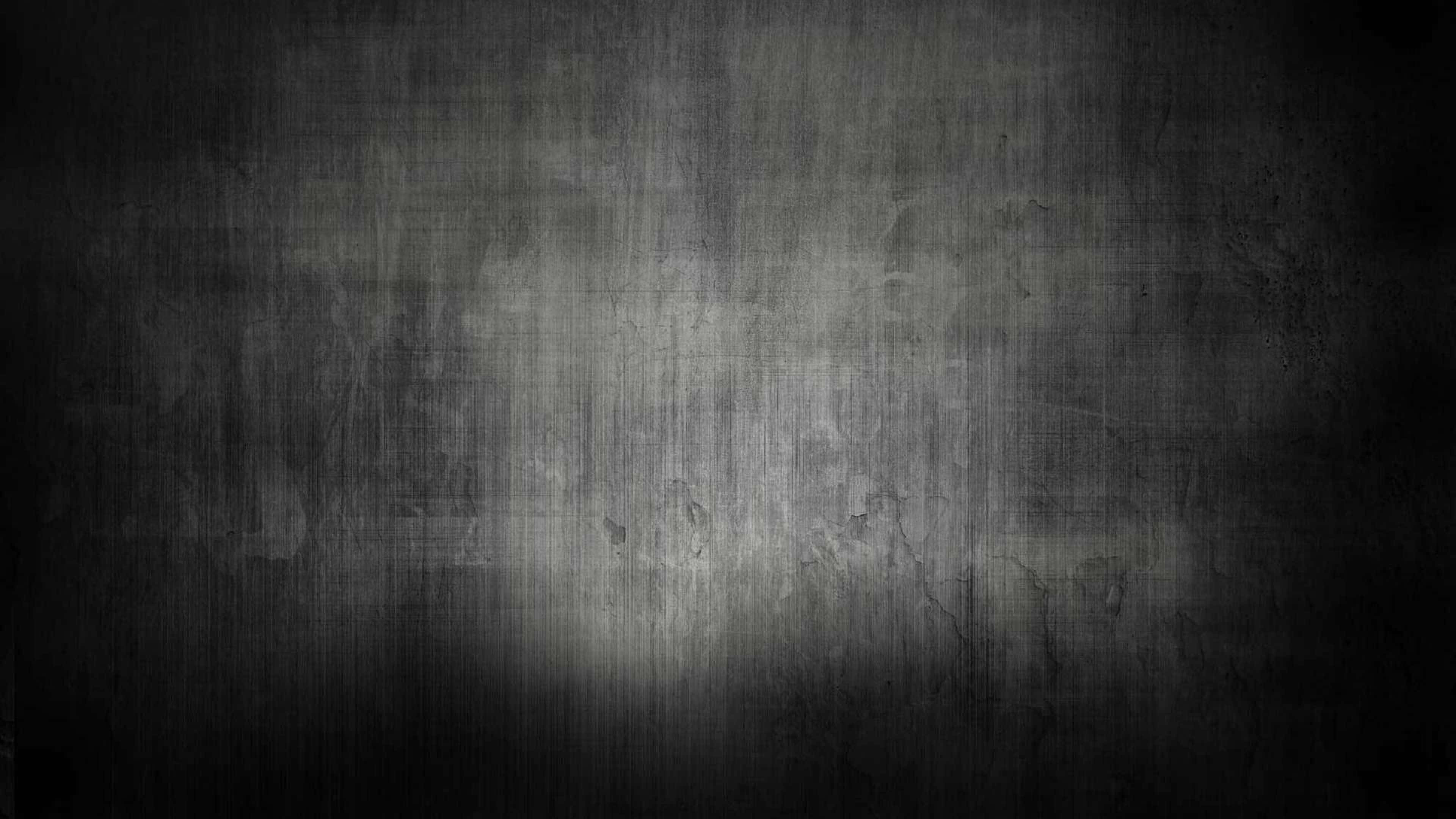 texture 桌布 壁紙 — 一面深色紋理牆壁，中央聚光燈照亮其粗糙表面。