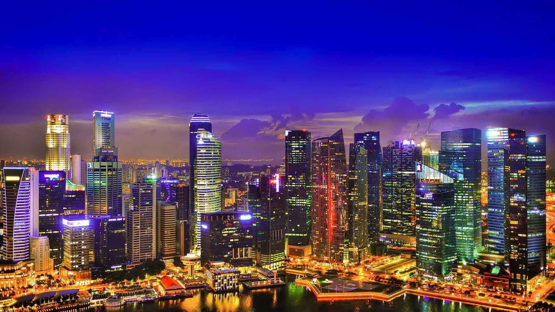 夜晚充滿活力的城市天際線，燈火通明的摩天大樓和水面倒影。