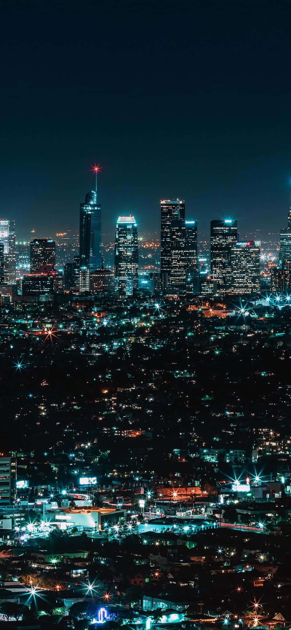 Best iPhone 桌布 壁紙 — 令人驚嘆的夜景，高聳的摩天大樓在黑暗的天空中閃耀。