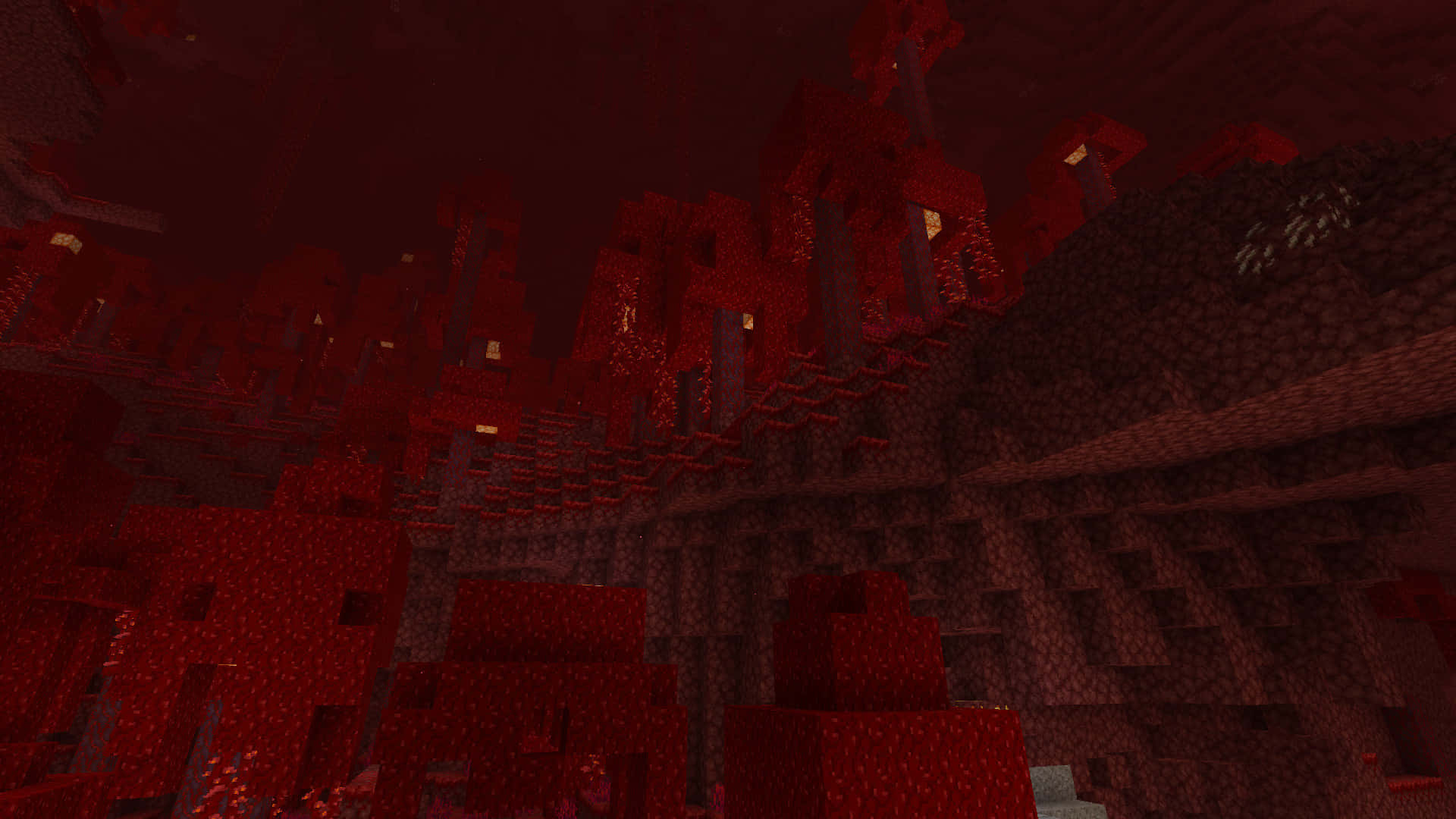  壁紙 — 一個燈光昏暗嘅Minecraft地獄堡壘，有鋸齒狀紅色方塊同發光嘅地獄火火炬。
