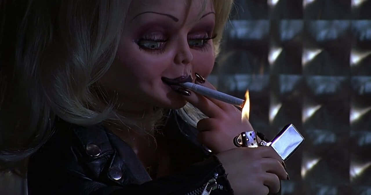  壁紙 — 一個像娃娃的金髮濃妝女人在昏暗的房間裡用閃爍的打火機點燃香煙。