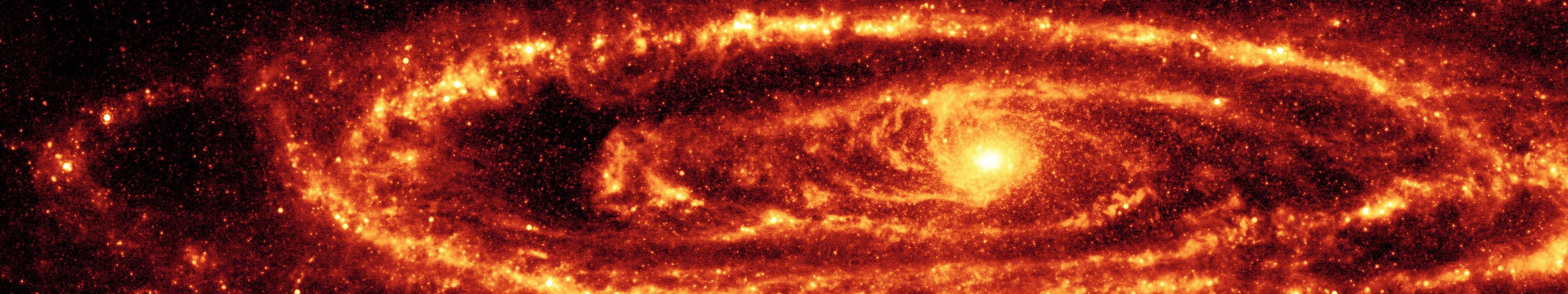 紅色仙女座星系視圖 壁紙 — 一個熾熱的螺旋星系在黑暗的宇宙背景下發出旋轉的橙色和紅色色調的光芒。
