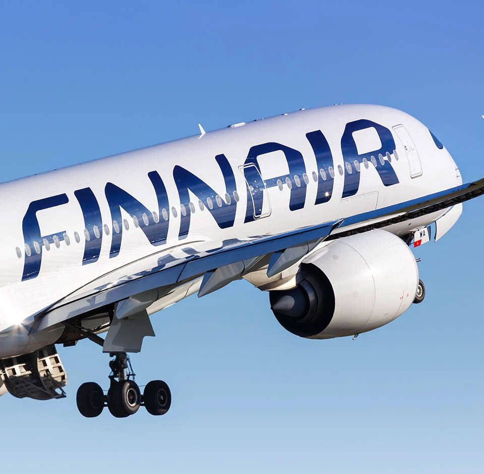 芬蘭航空字母標誌 壁紙 — 芬蘭航空飛機在飛行中，起落架放下，背景是清澈的藍天。