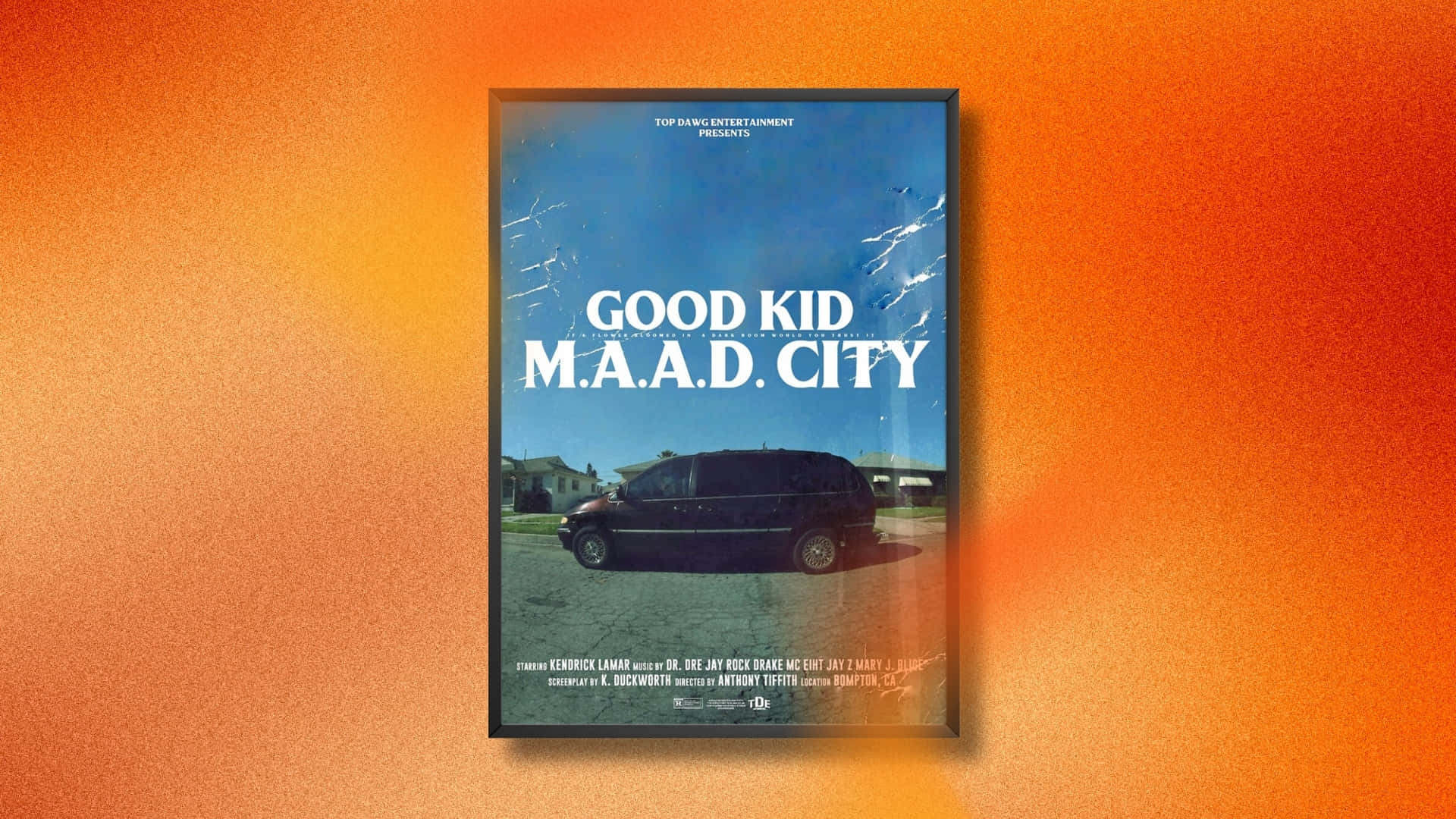  壁紙 — 一幅裱框嘅電影海報《Good Kid M.A.A.D City》掛喺有紋理嘅橙色漸變牆上。
