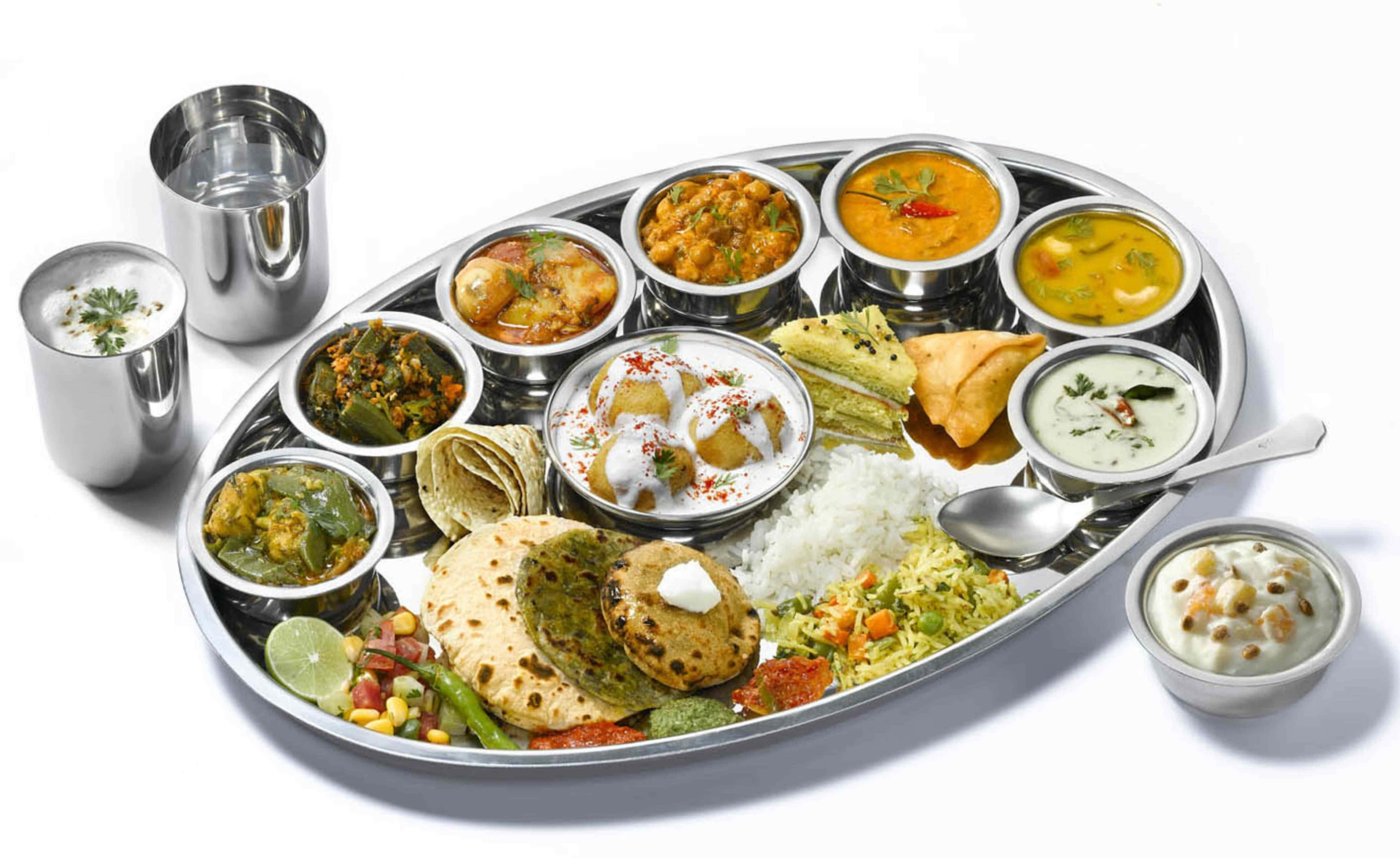 Thali 桌布 壁紙 — 一個閃亮的金屬塔利盤，盛滿色彩繽紛的印度咖喱、烤餅、米飯和酸辣醬，為一場充滿活力的盛宴而擺設。