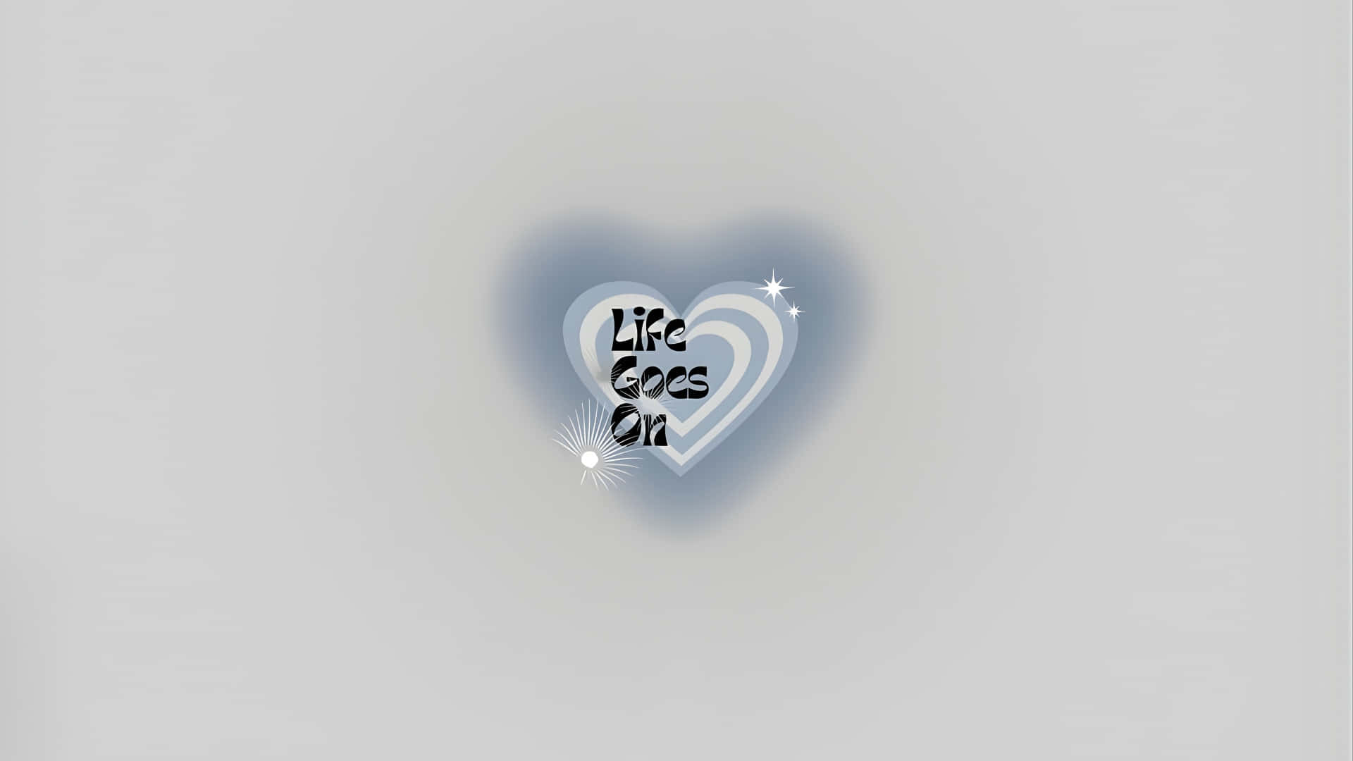  壁紙 — 一顆發光的心臟，帶有文字 Life Goes On，在柔和的灰色背景上柔和地散發光芒。