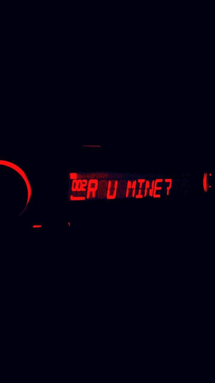 紅色發光文字在黑色背景上問「Are U Mine?」。