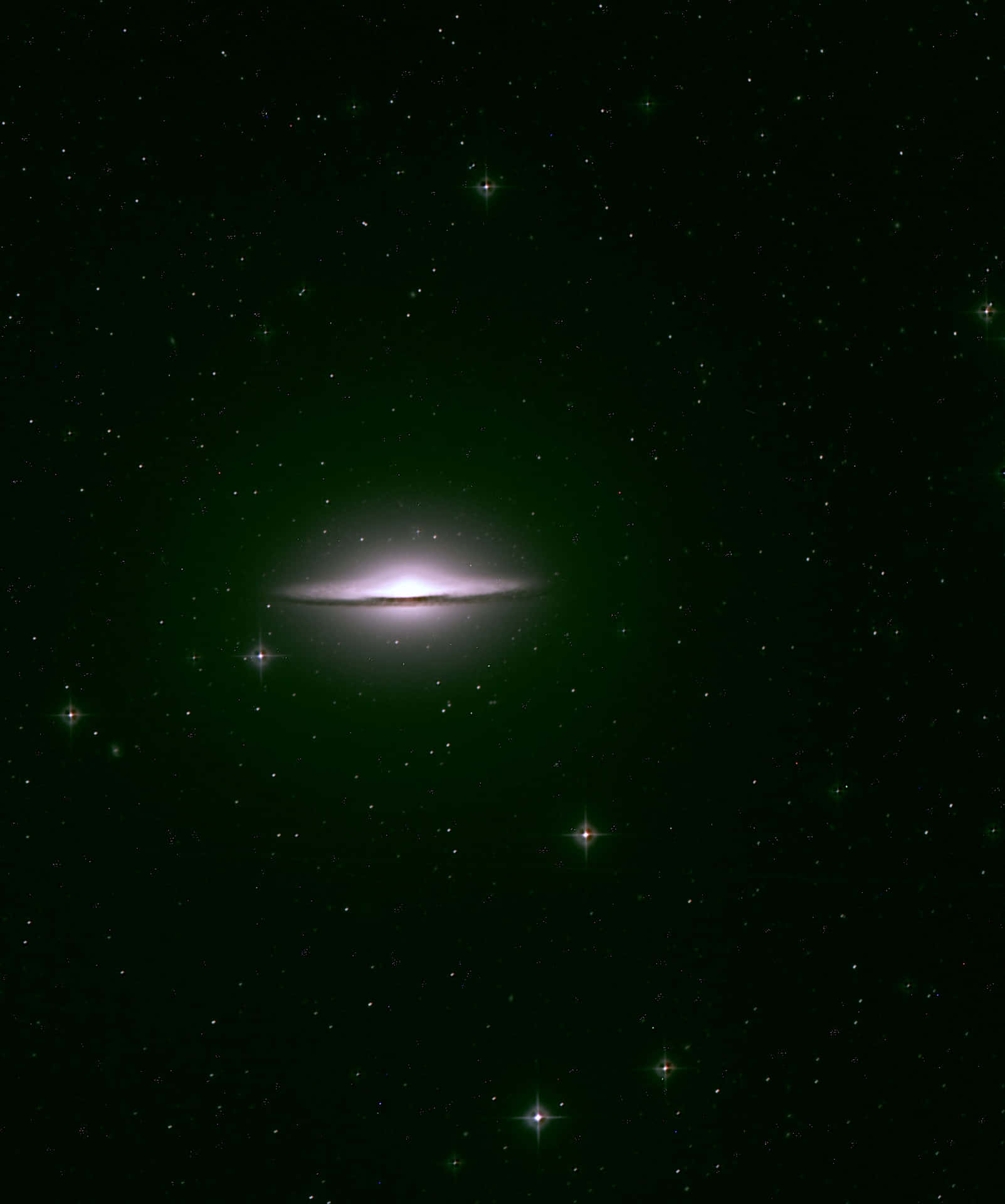  壁紙 — 一個發光的螺旋星系，帶有明亮的核心和綠色光暈，漂浮在深空閃爍的星場中。
