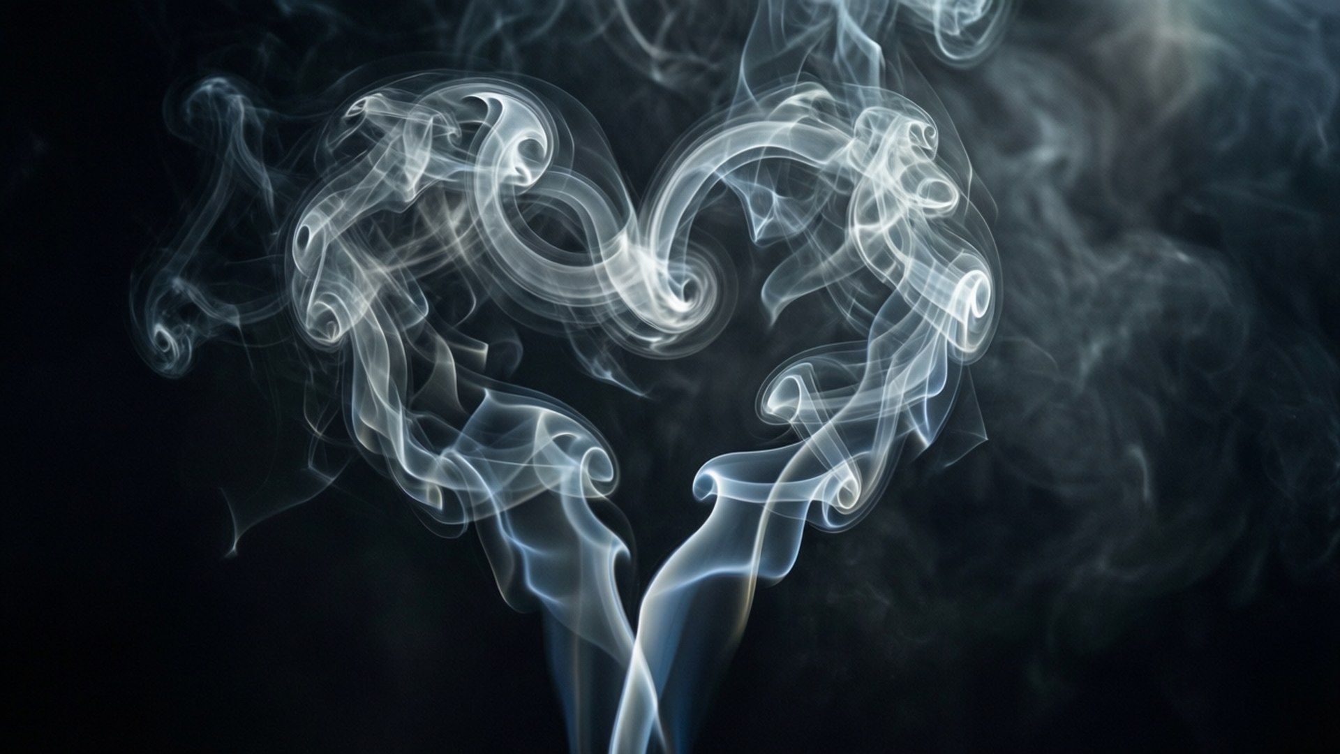 由旋轉煙霧在深色背景上形成的愛心形狀。