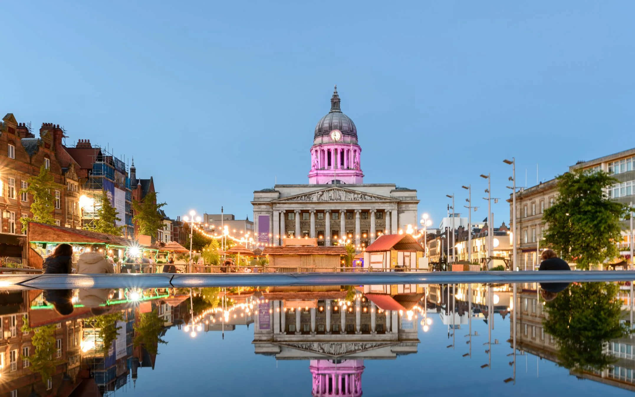Nottingham 桌布 壁紙 — 一座宏偉的新古典主義建築，帶有粉紅色照亮的圓頂，在暮色中完美倒映在平靜的水景中。