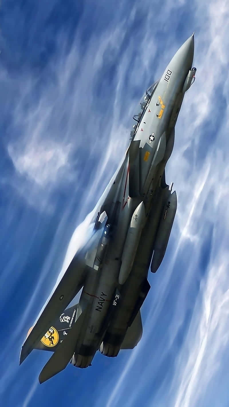  壁紙 — 一架灰色海軍戰鬥機穿過帶有縷縷白雲的鮮豔藍天向上飛升。
