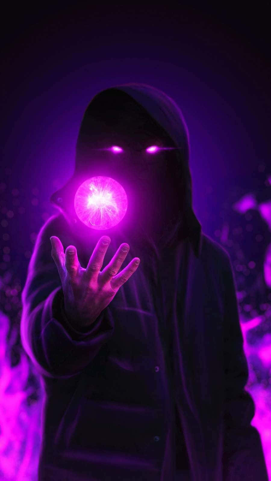  壁紙 — 一個戴著兜帽的身影在黑暗中手持一個發光的紫色球體，從他們伸出的手中散發出輻射能量。