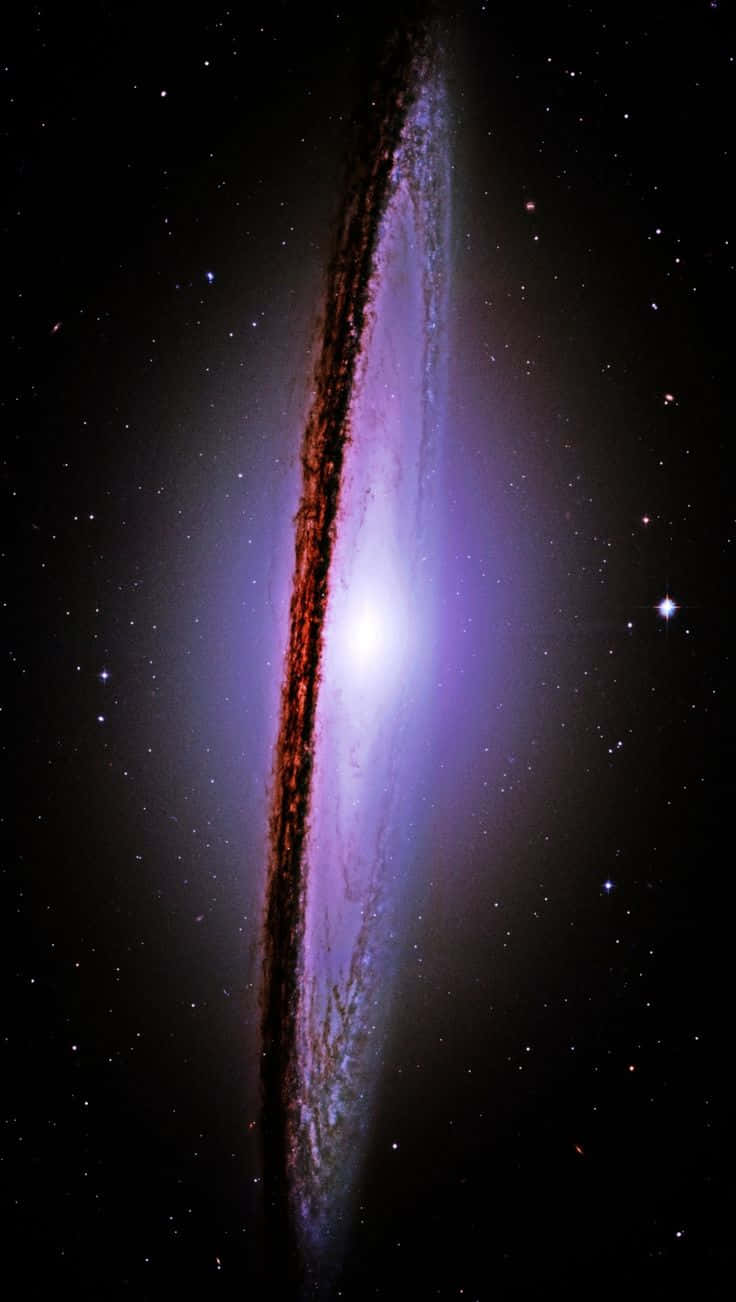  壁紙 — 一個宏偉的螺旋星系在星空背景下散發出紫色和紅色的光芒。