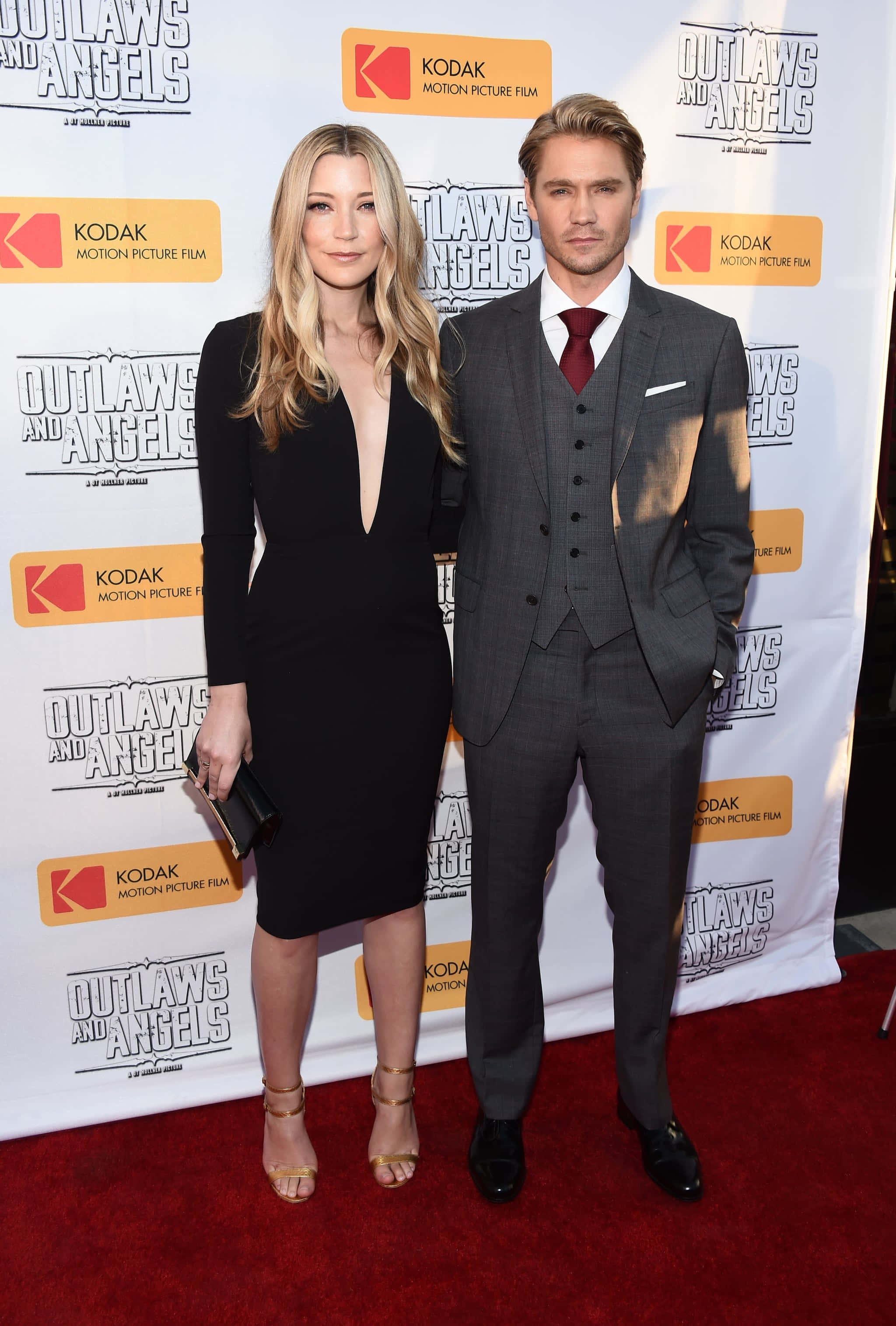 Sarah Roemer 桌布 壁紙 — 一男一女在電影首映禮的紅地毯上自信地擺姿勢，背景帶有品牌標誌。