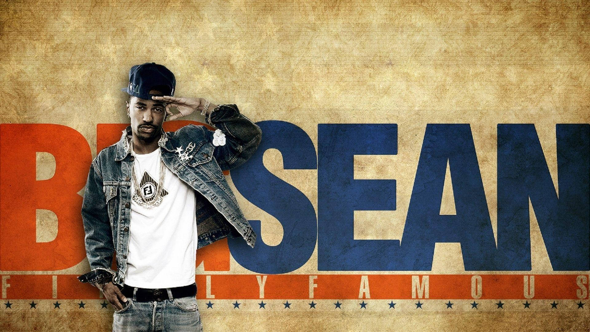 棕色專輯封面 Big Sean 壁紙 — 一名身穿牛仔外套和帽子的男子，在帶有粗體橙色和藍色「BRISEAN」字樣的紋理背景前敬禮。