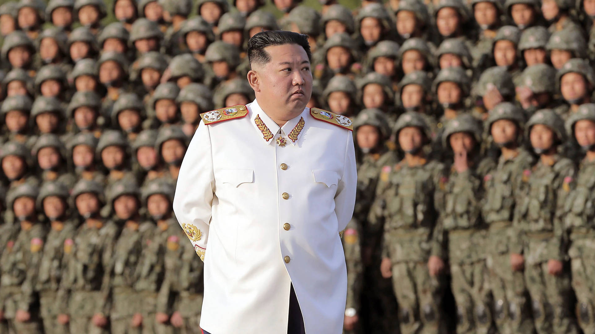 一名身穿白色軍裝的男子站在一排排士兵面前。