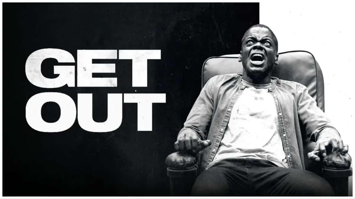  壁紙 — 一個男人坐在椅子上，旁邊有粗體白色文字寫著「GET OUT」，背景是純黑色，他恐懼地尖叫。