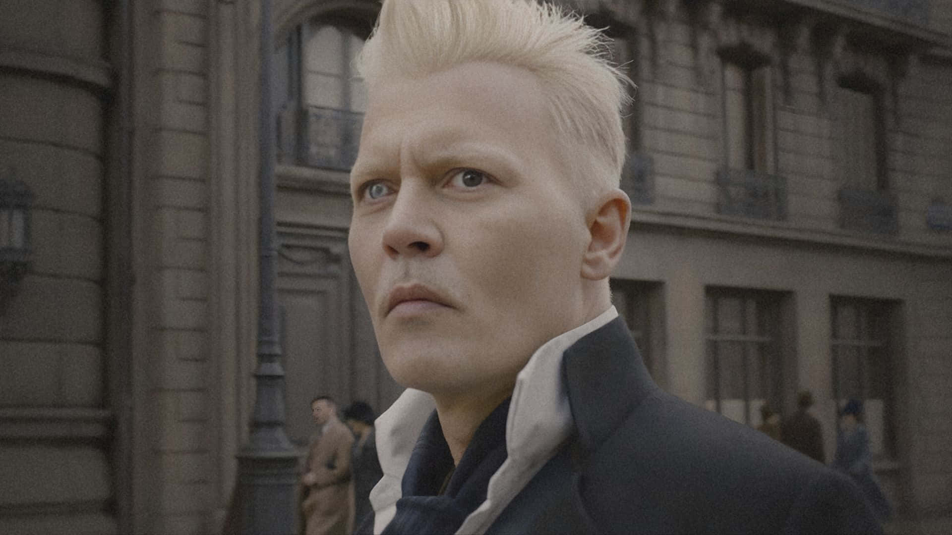  壁紙 — 一個擁有鉑金色頭髮和強烈藍眼睛的男人，在一條有石頭建築和模糊行人的復古城市街道上向前凝視。