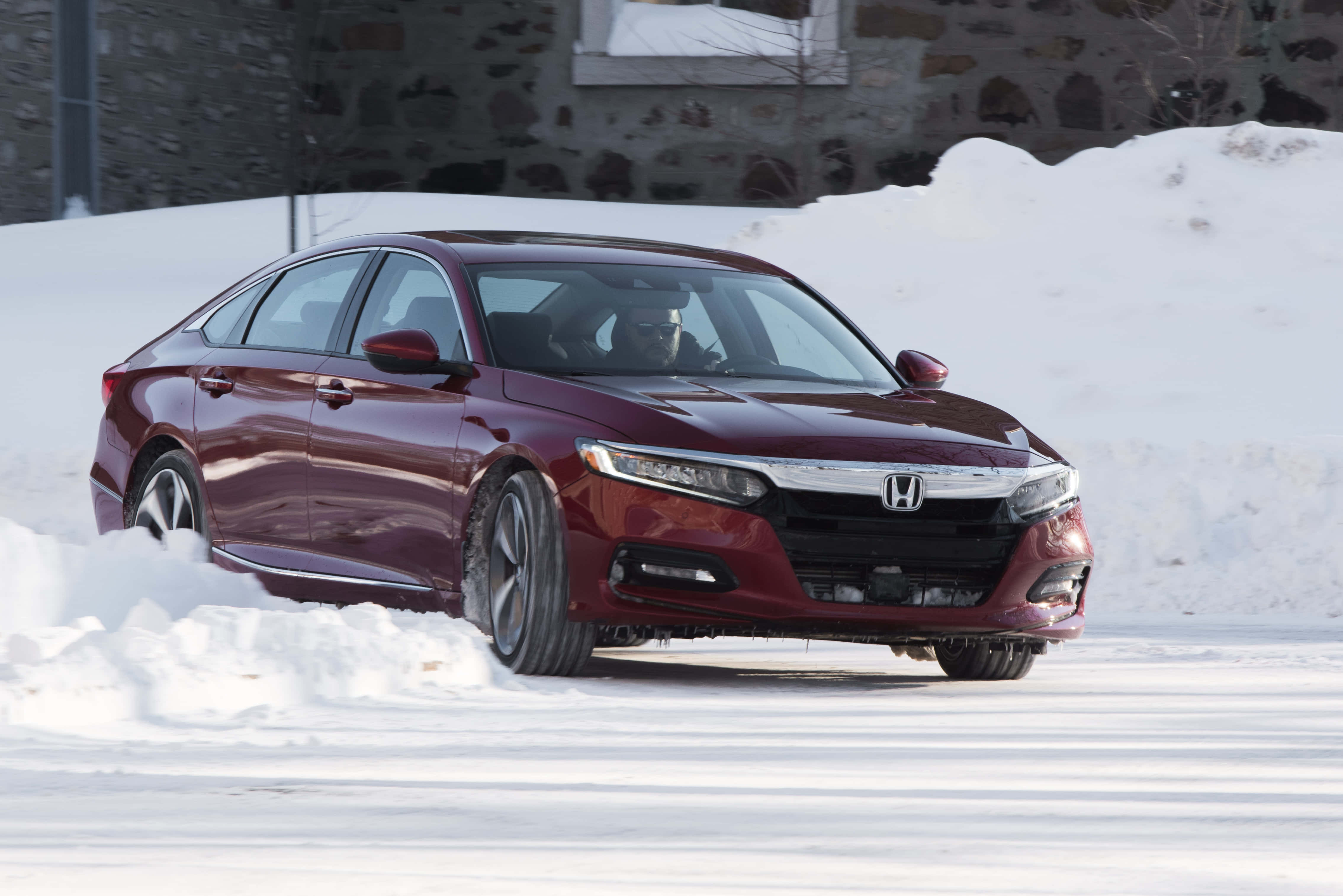 Honda Accord 桌布 壁紙 — 一輛栗色本田房車在明亮的冬日陽光下行駛在石建築旁的深雪中。