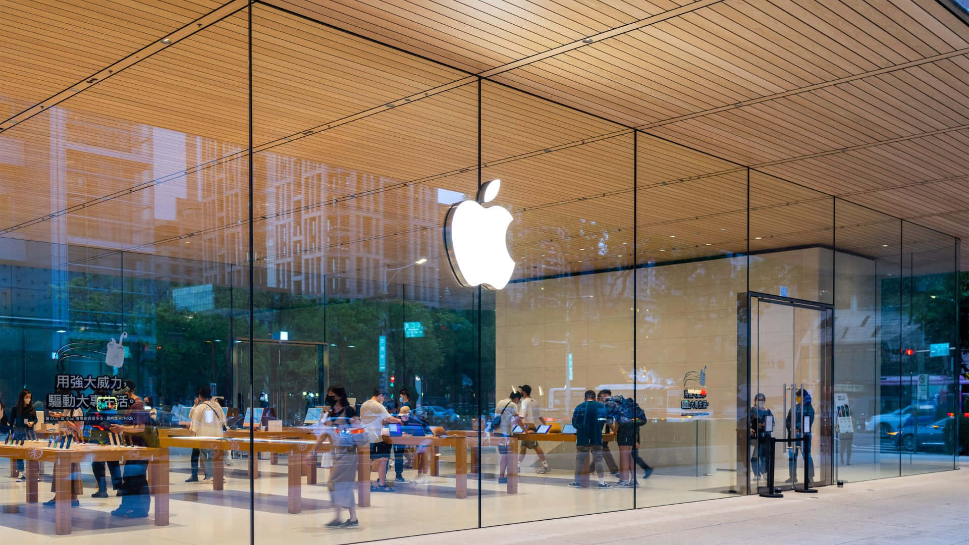 Apple Store設有玻璃牆和木質天花板，展示顧客瀏覽產品。