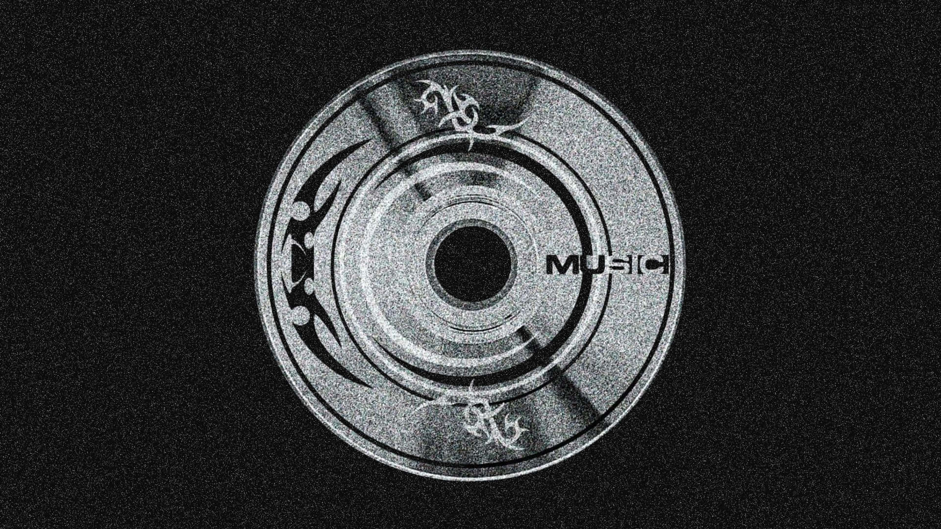  壁紙 — 一張單色CD，帶有'MUSIC'文字和部落圖案，在粗糙的黑色背景上發光。