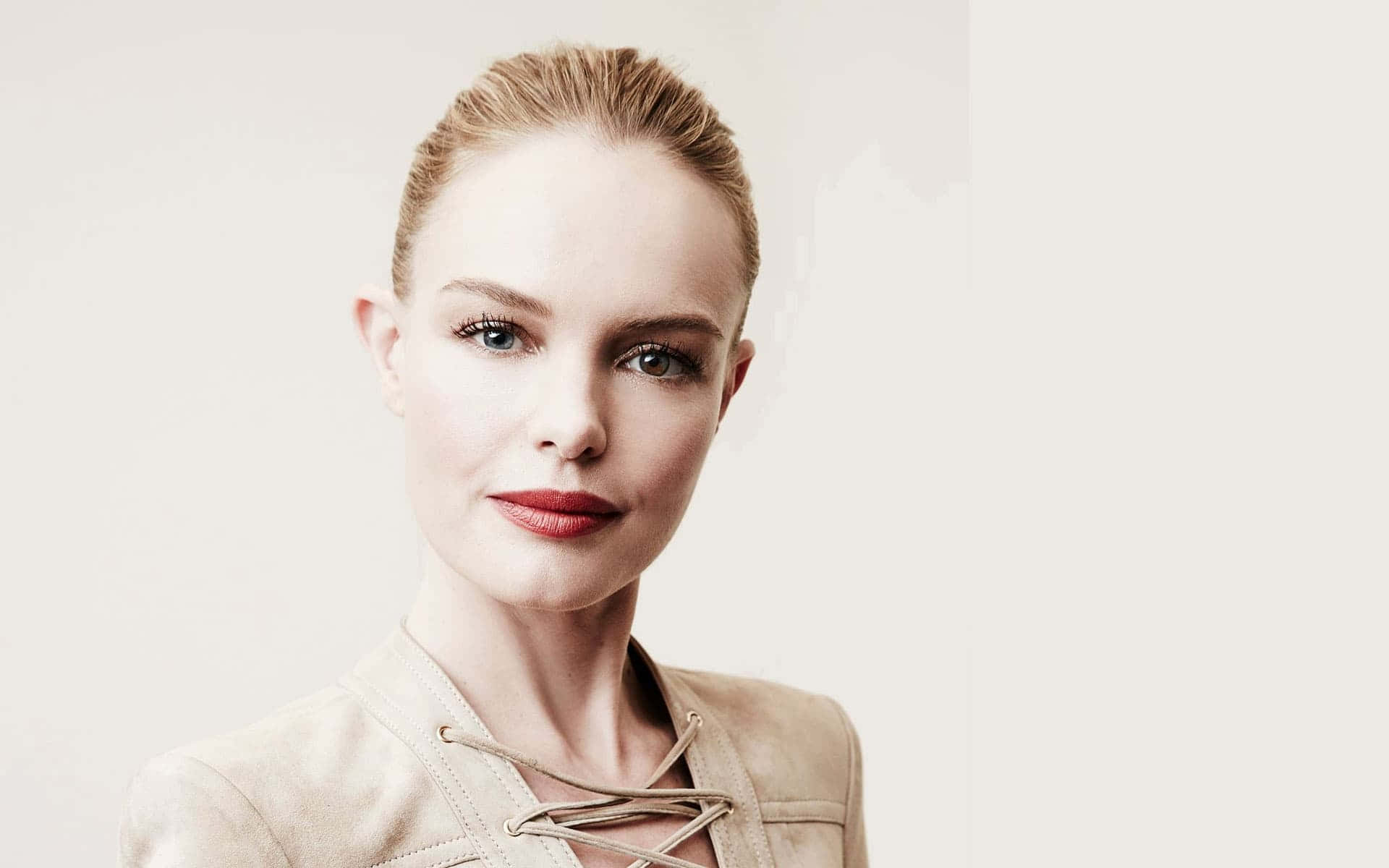 Kate Bosworth 桌布 壁紙 — 一位金髮紅唇的優雅女性，在柔和的中性背景前平靜地凝視鏡頭。