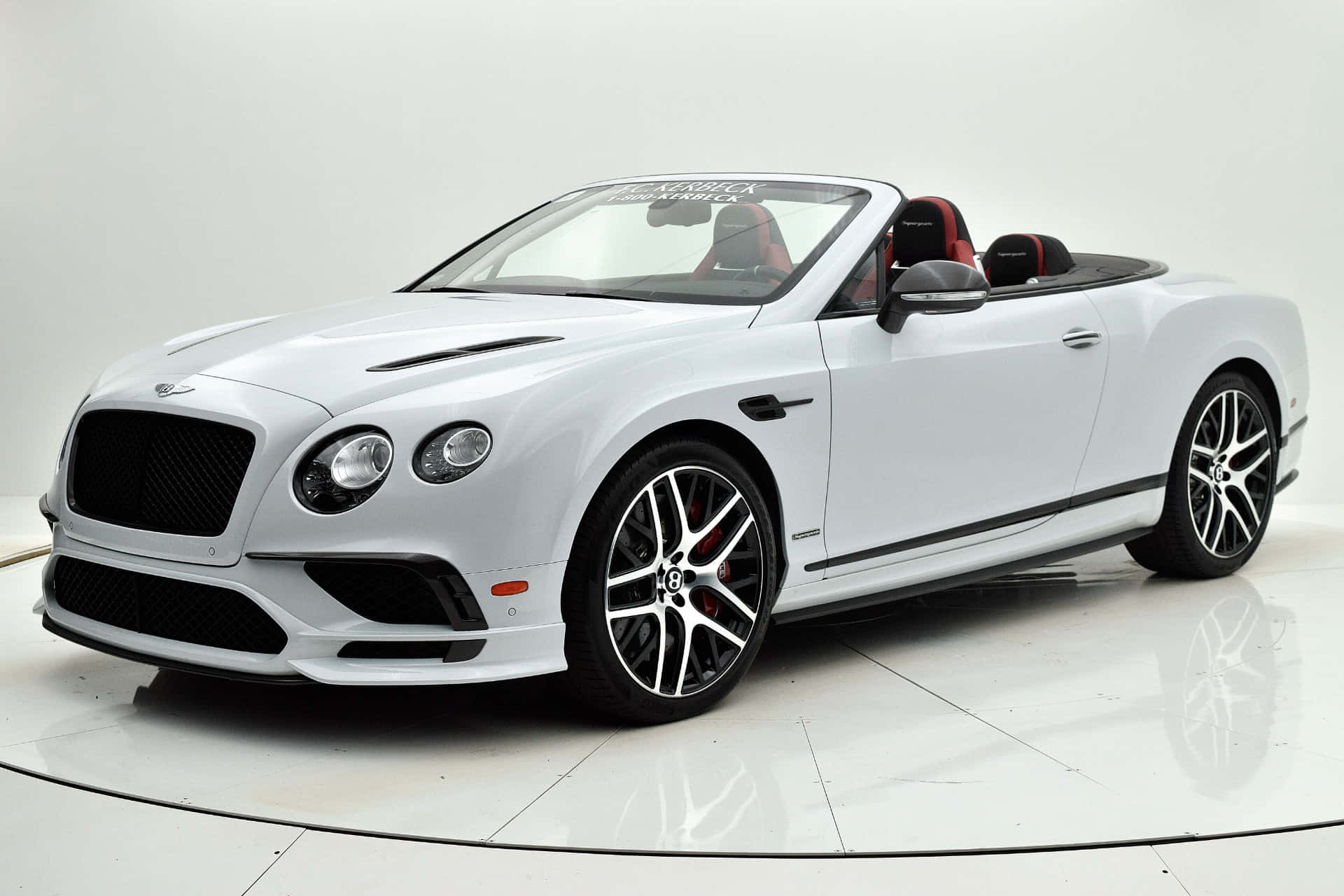 Bentley Continental Supersports 桌布 壁紙 — 一輛純白色的賓利 Continental GT 開篷跑車，配備紅色內飾和黑色飾邊，在明亮的攝影棚中展示。