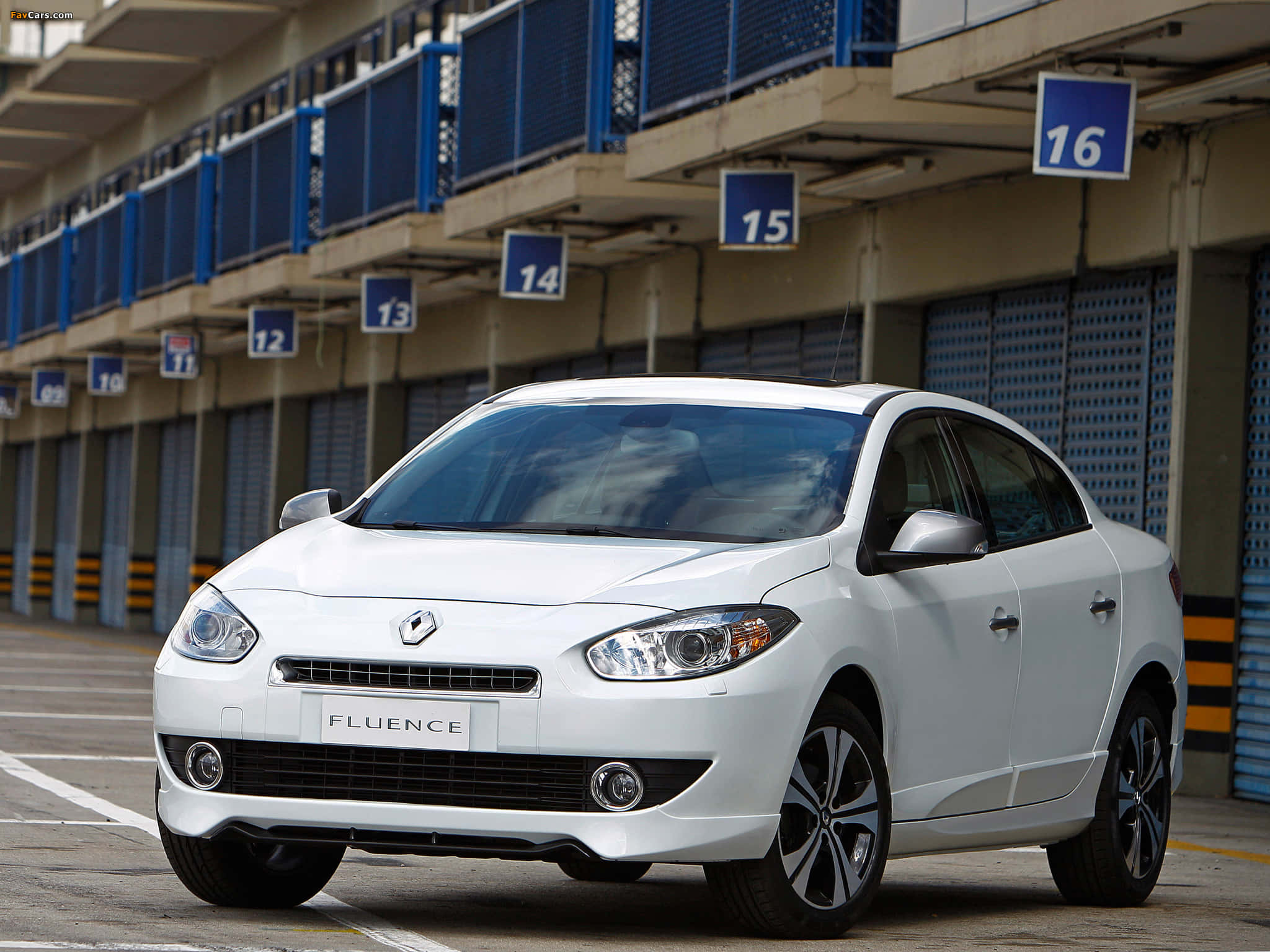 Renault Fluence 桌布 壁紙 — 一輛純白色的雷諾Fluence房車停在一個有編號的工業車庫車位，在明亮的日光下。