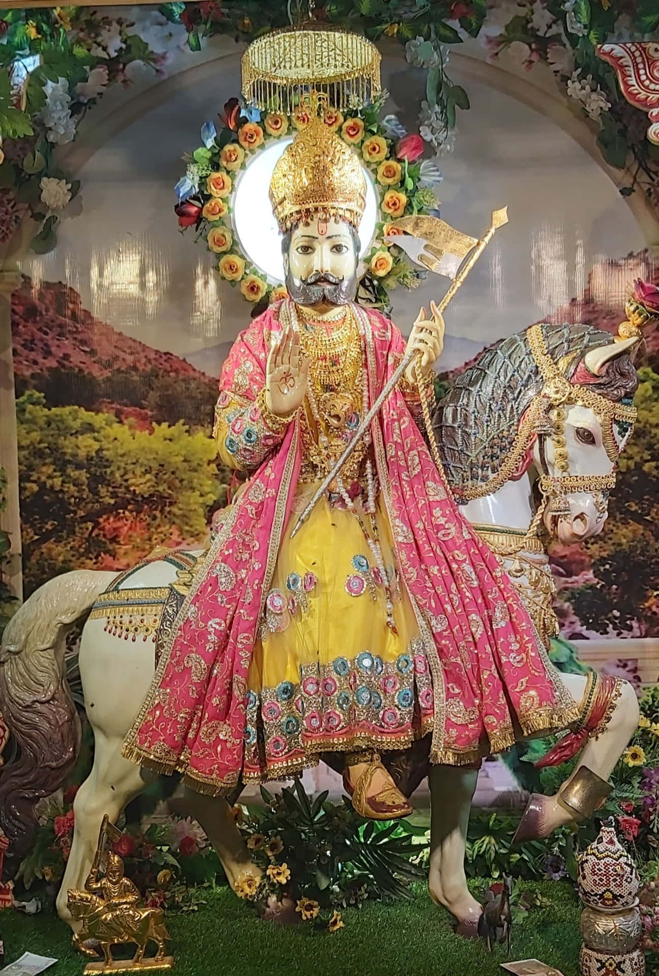  壁紙 — 一尊鬍鬚神祇的華麗雕像，身穿粉紅與金色長袍，騎著白馬，在花拱下，背景是發光的月亮。