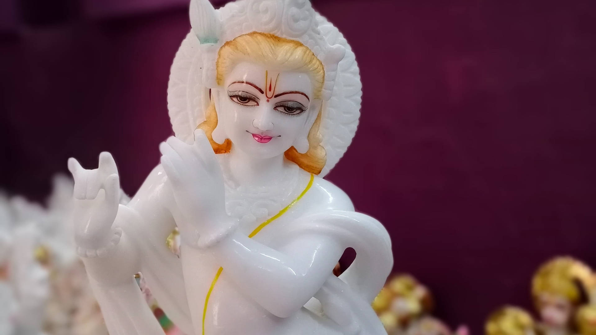 一尊微笑的白色大理石神像，金髮，帶光環。