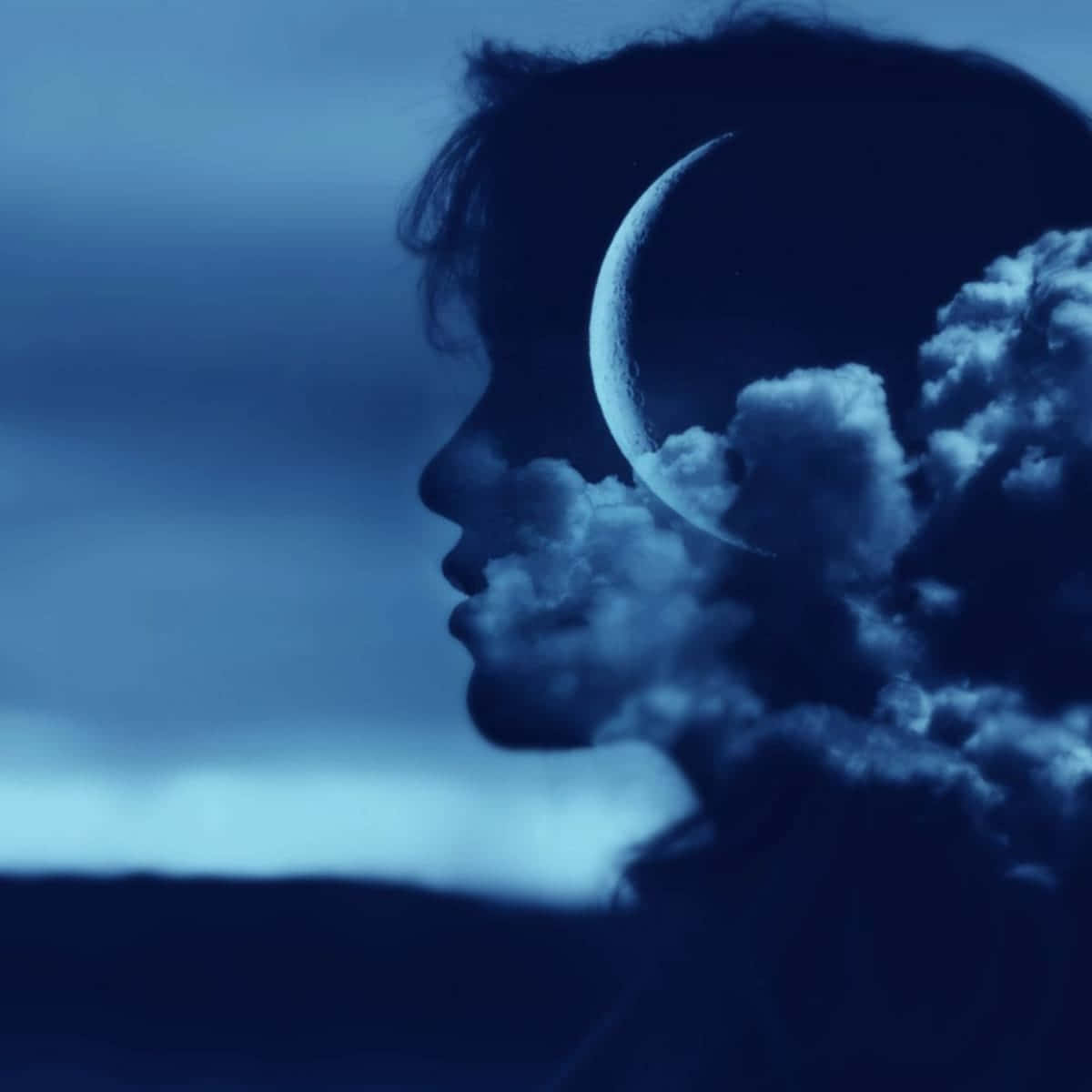 壁紙 — 一個人的側面剪影，新月和雲朵從他們的頭部浮現，背景是暮色天空，呈現寧靜的畫面。