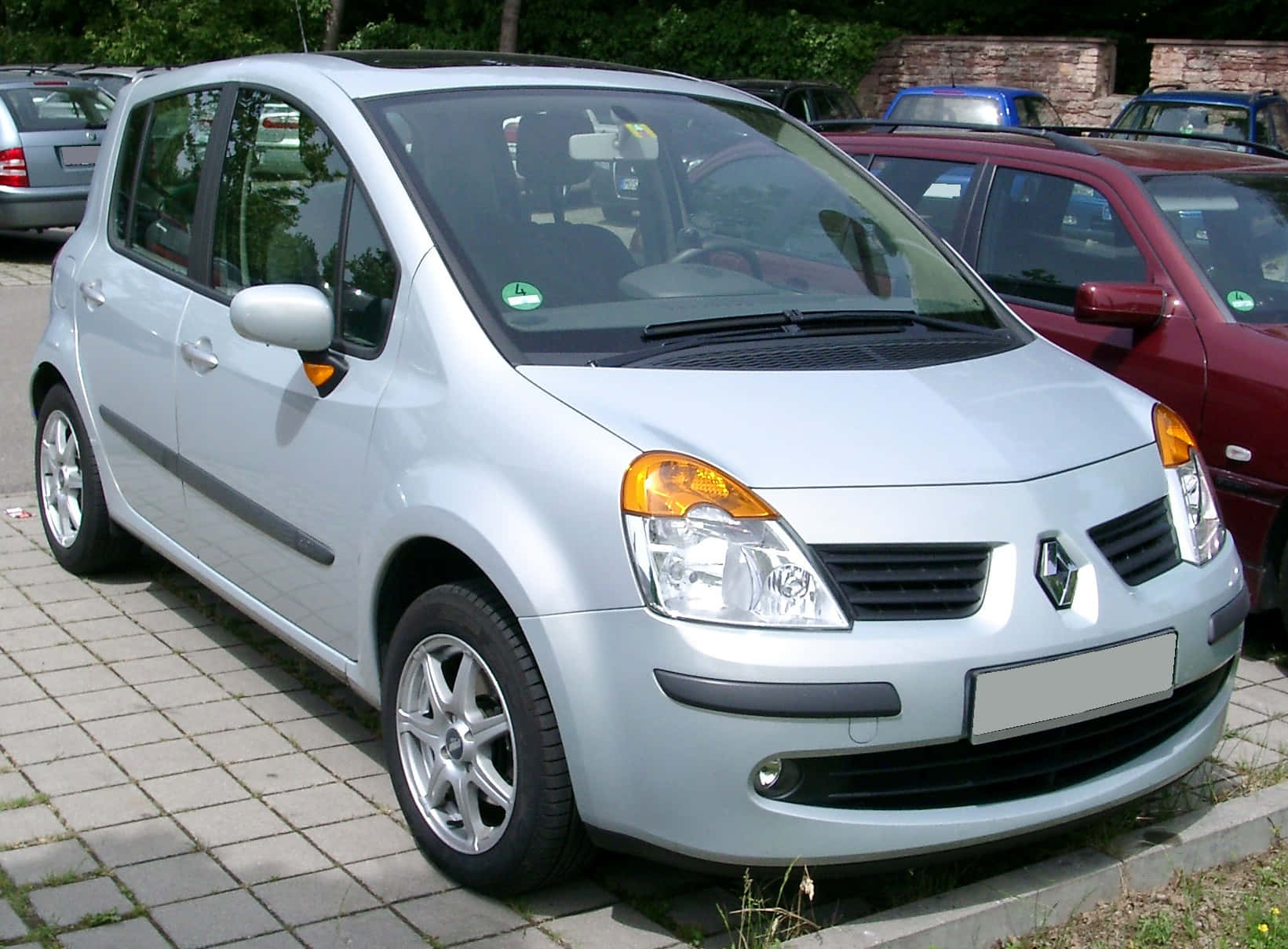 Renault Modus 桌布 壁紙 — 一輛銀色雷諾Modus停泊在鋪砌的停車場上，背景有其他車輛，在日光下。