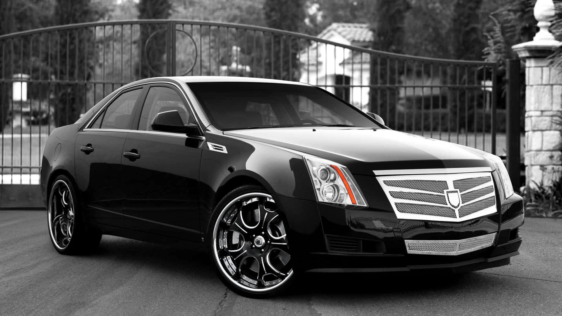 Cadillac Cts 桌布 壁紙 — 一輛時尚的黑色Cadillac CTS-V轎車配備定制輪圈，停在華麗的金屬大門前。