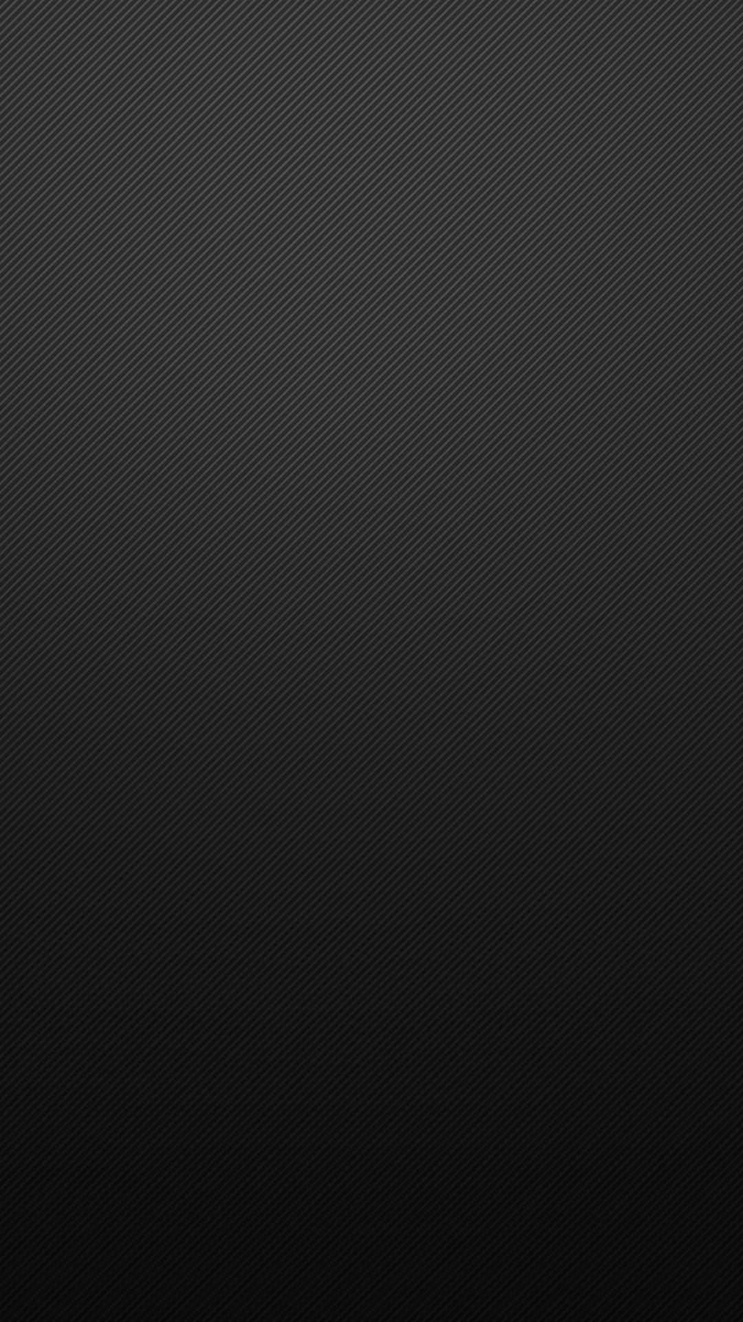 用這款 iPhone 獲得時尚碳纖維外觀 壁紙 — 光滑黑色碳纖維紋理，帶有對角線條，逐漸淡入更深陰影。