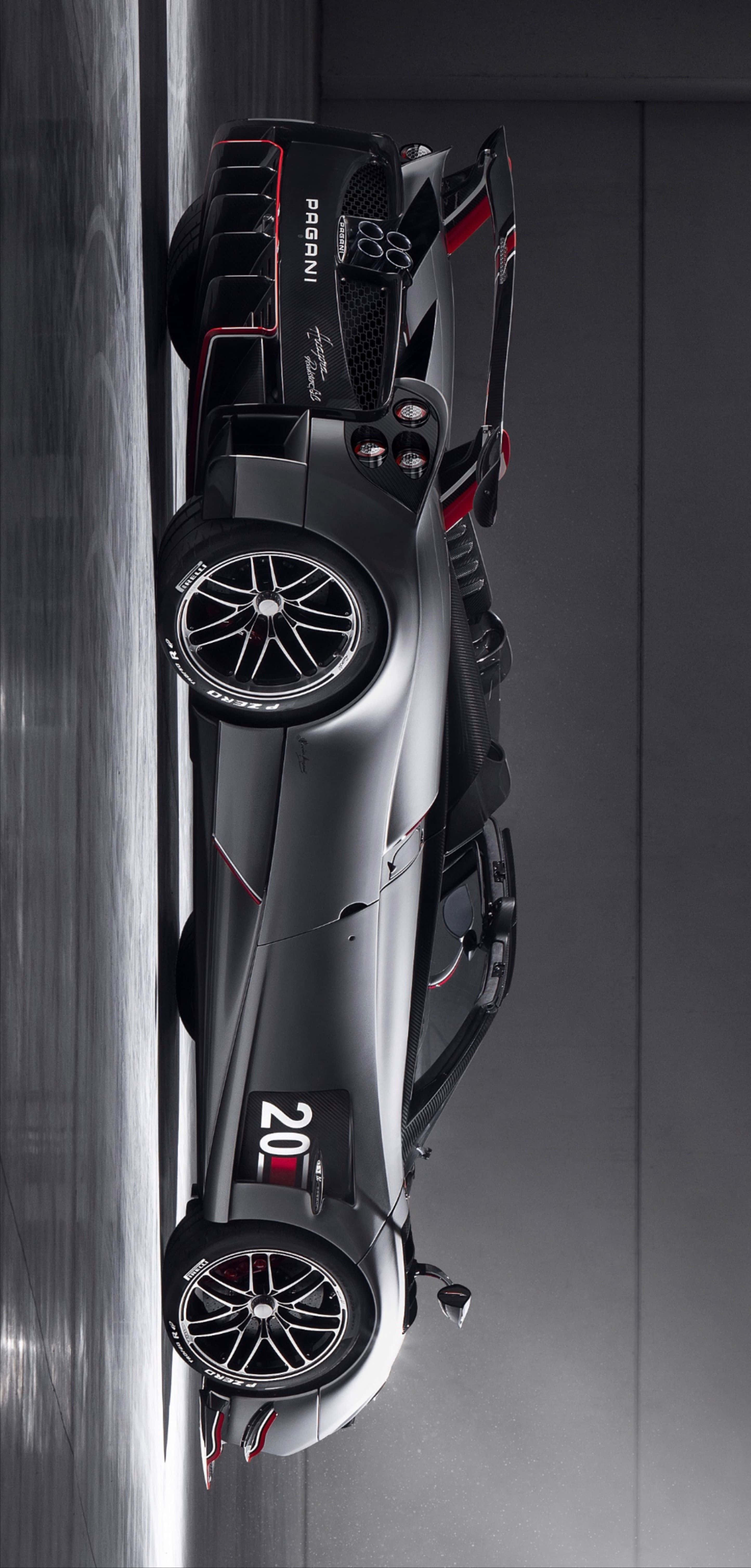 Pagani Huayra Roadster Bc 桌布 壁紙 — 從上方俯瞰，一輛帶有紅色點綴的時尚黑色帕加尼超跑，置於簡約工作室環境中。