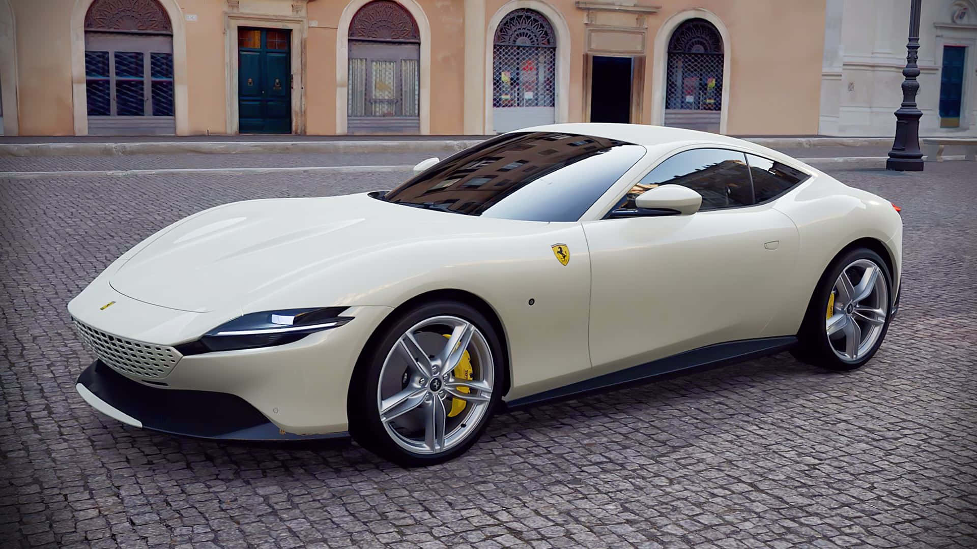 Ferrari Roma 桌布 壁紙 — 一架時尚的奶油色法拉利 Roma 停泊在鵝卵石街道上，前方是古典歐洲建築。