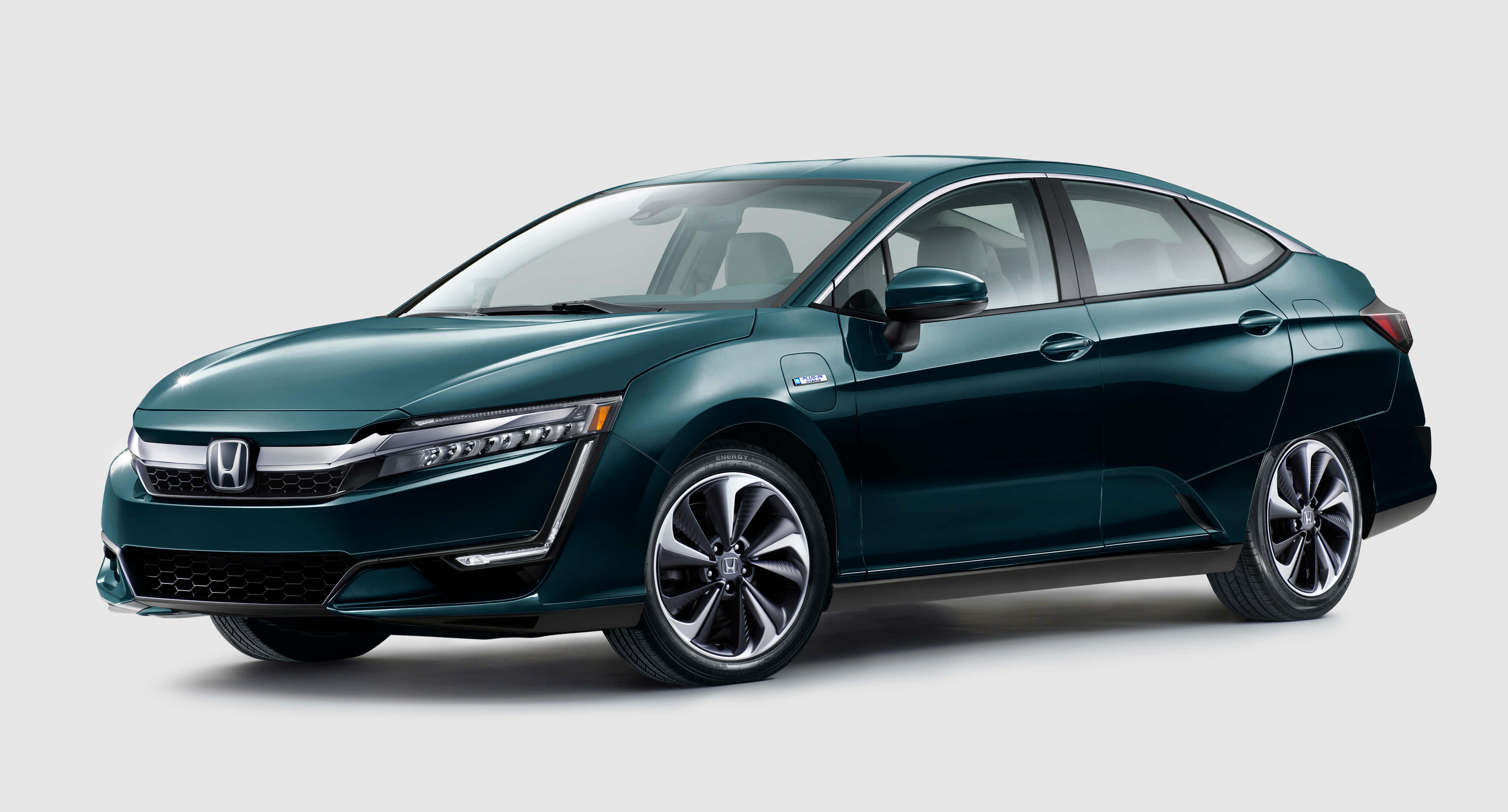 Honda Clarity 桌布 壁紙 — 時尚深青綠色本田Clarity插電式混合動力轎車，在工作室燈光下以潔白背景展示。