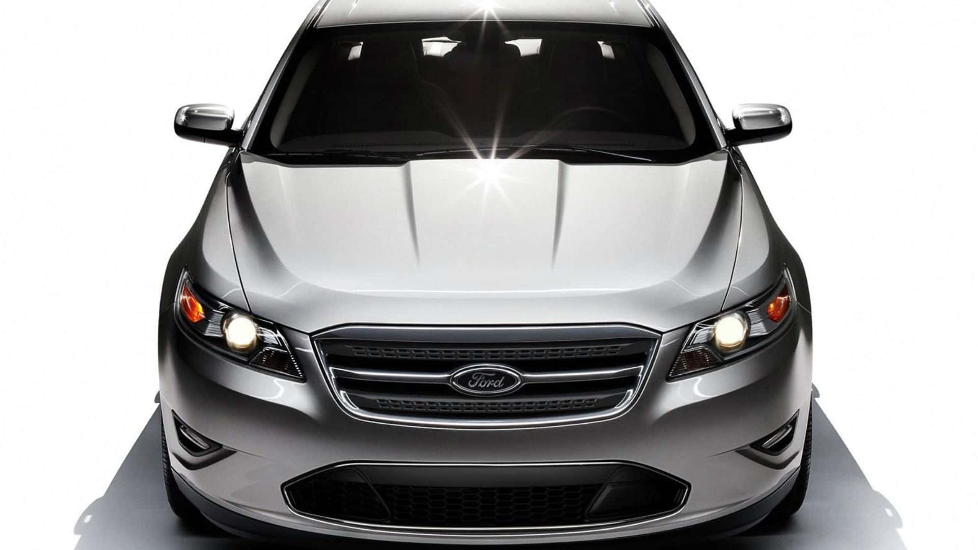 Ford Taurus 桌布 壁紙 — 一架時尚的銀色福特房車在攝影棚燈光下閃耀，引擎蓋上帶有明亮的星芒效果。