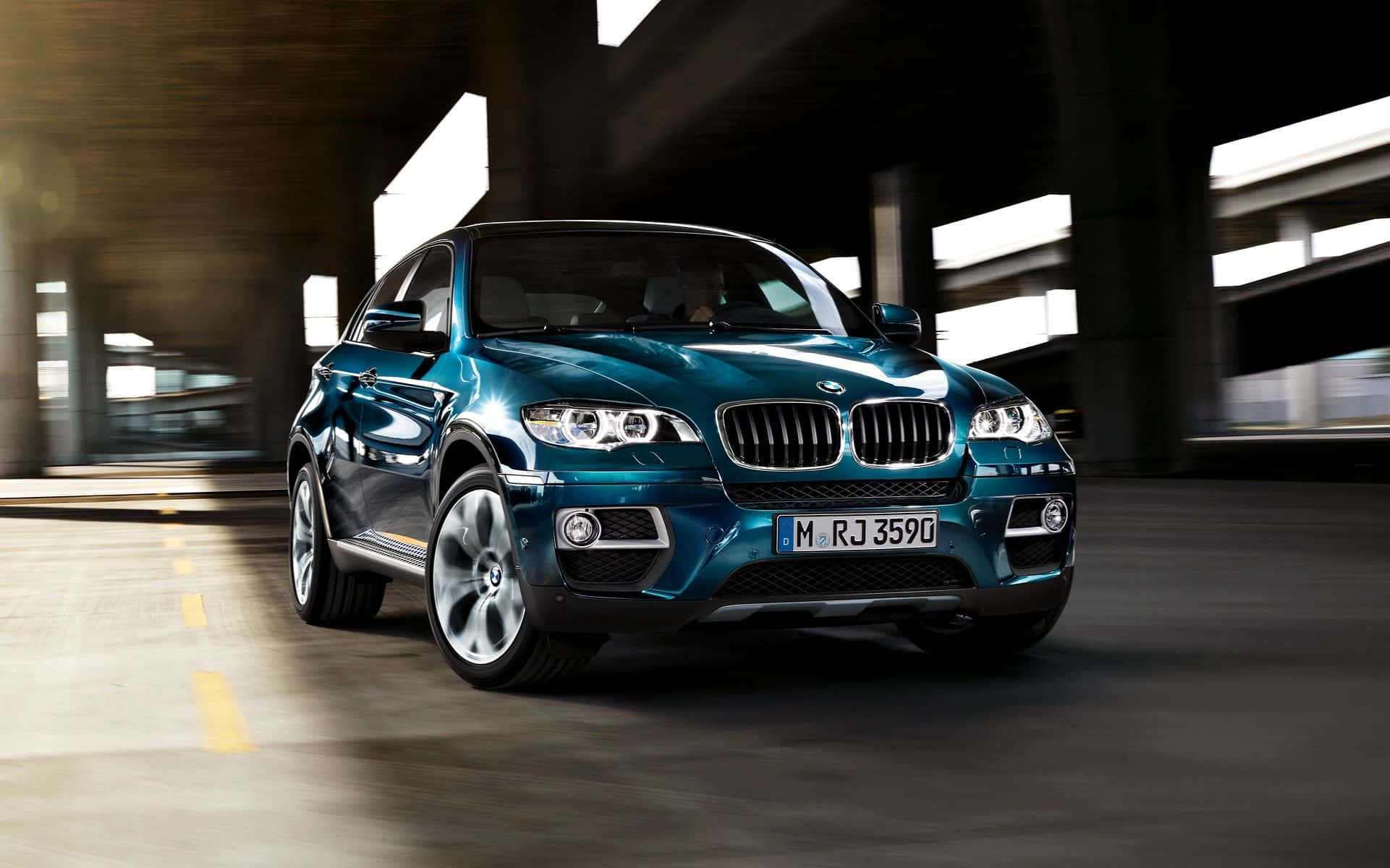 Bmw X6 桌布 壁紙 — 一架時尚的青綠色BMW X6在混凝土地下通道中疾馳，動態模糊突顯其動感。